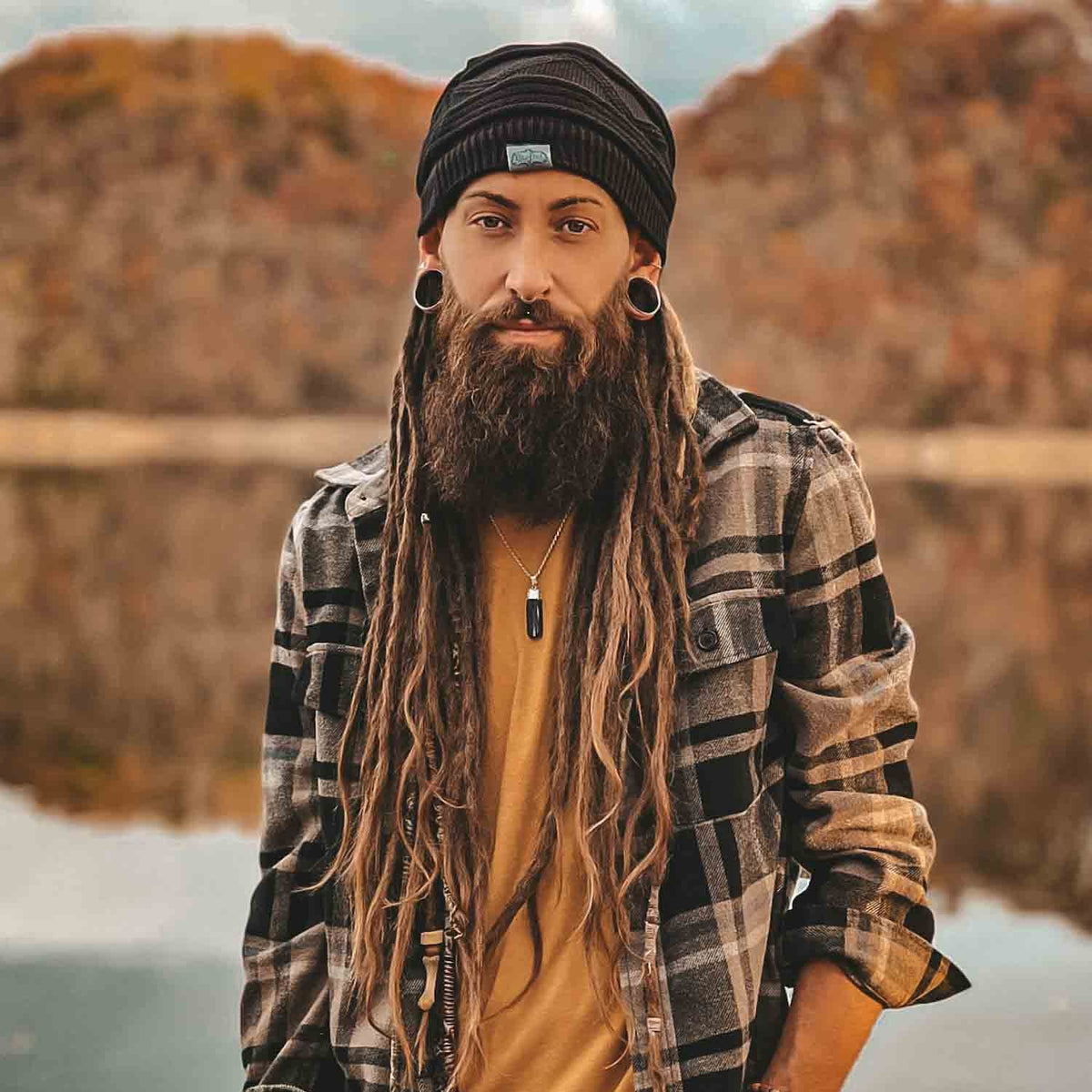 Person wearing a black CrafterElena Triangle beanie with long locs