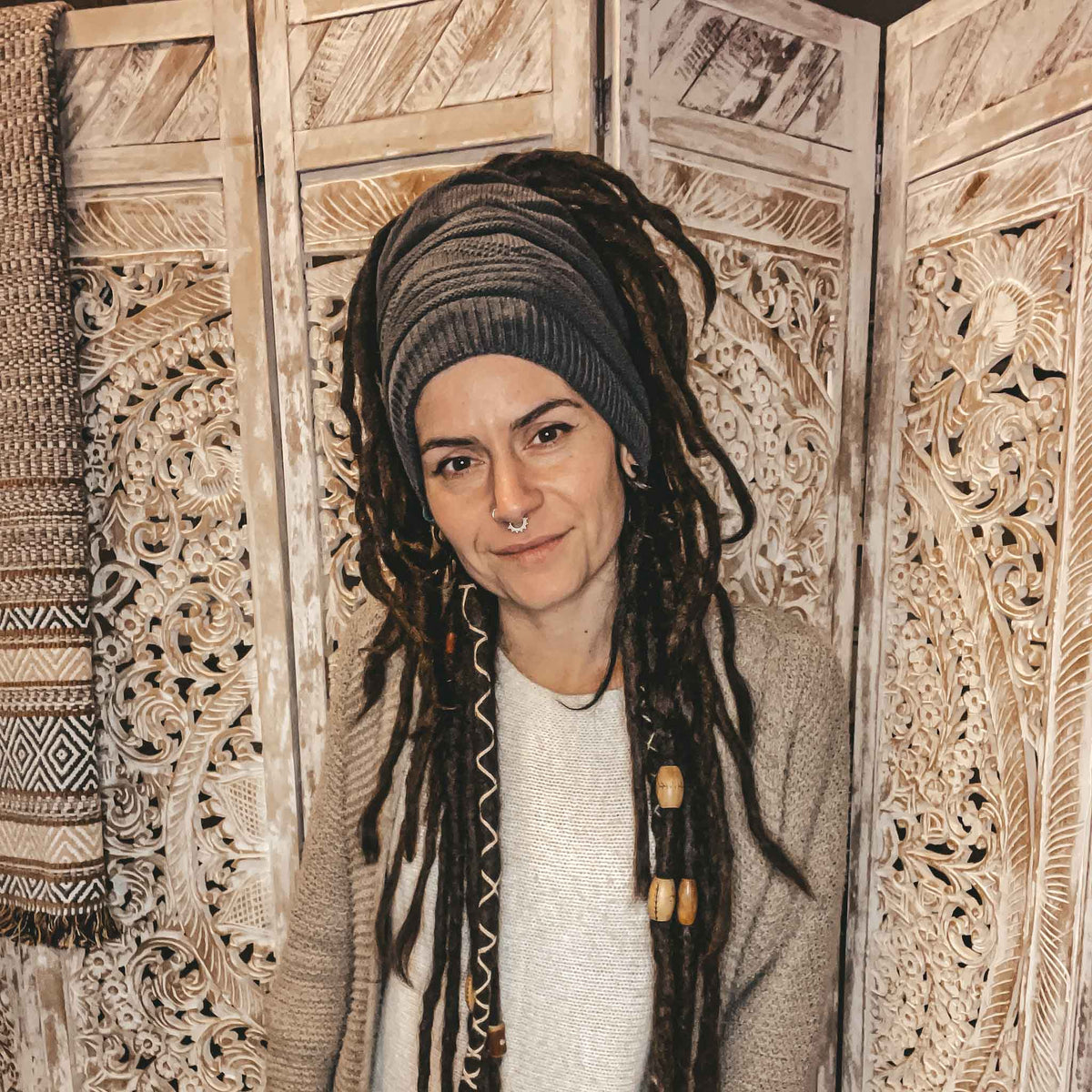 Person wearing a dark grey CrafterElena Triangle beanie with locs