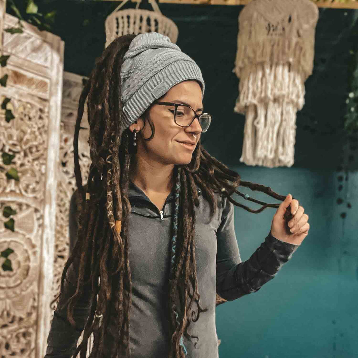 Person wearing a light grey CrafterElena Triangle beanie with locs