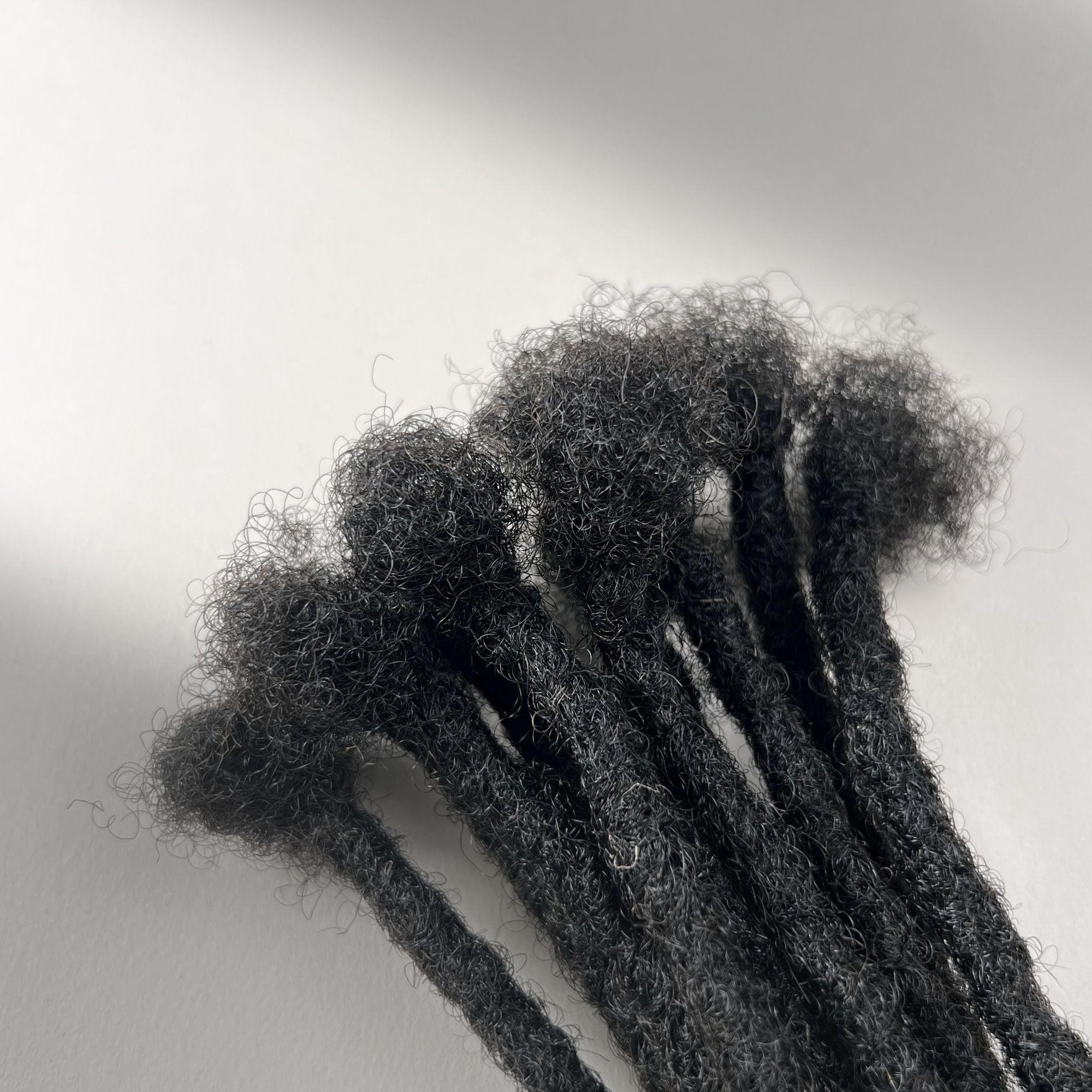Close-up of the connection point on Dark Brown kinky human hair loc extensions.
