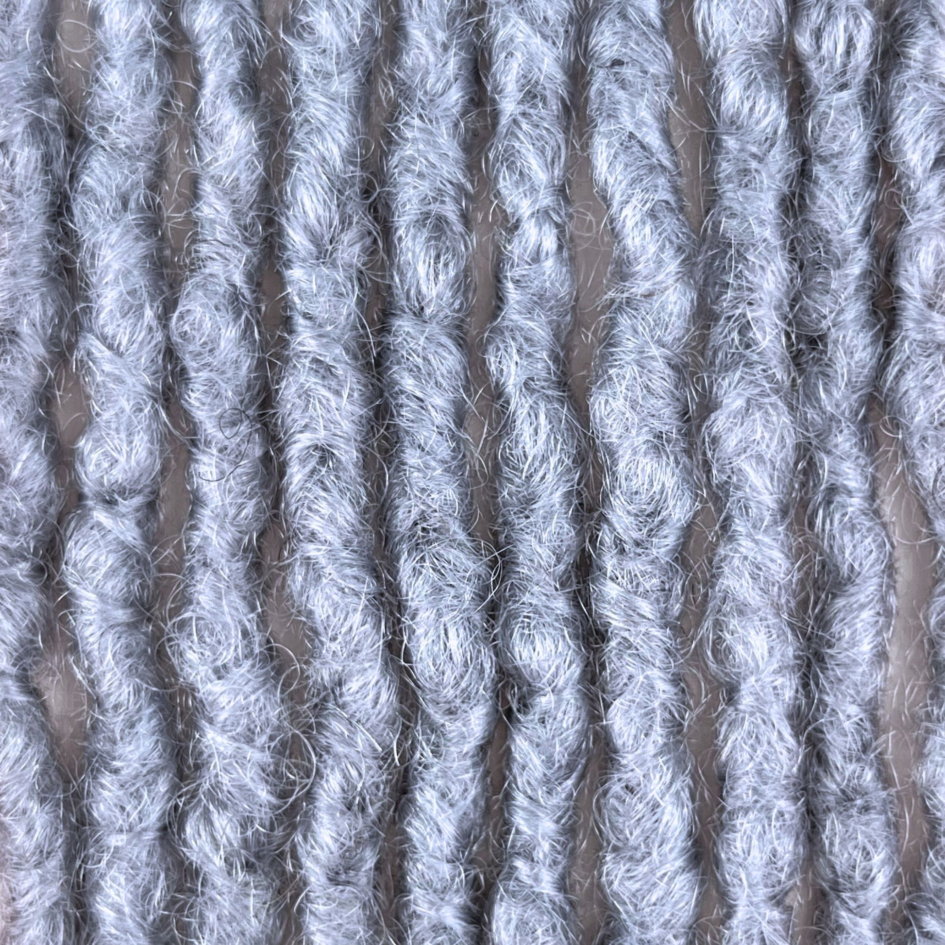 Close-up of Grey kinky human hair loc extensions made using the interlocking method.