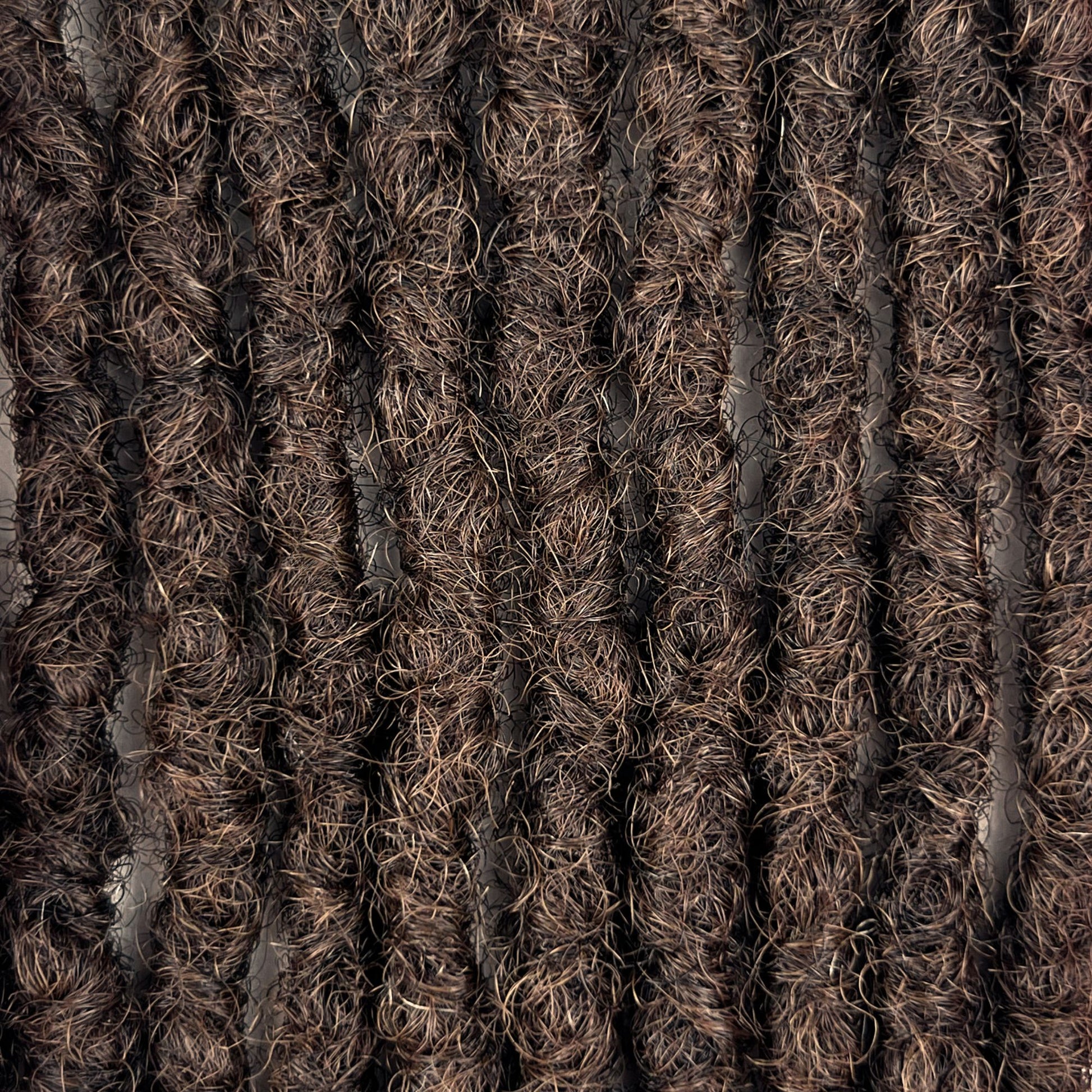 Close-up of Medium Brown kinky human hair loc extensions made using the interlocking method.