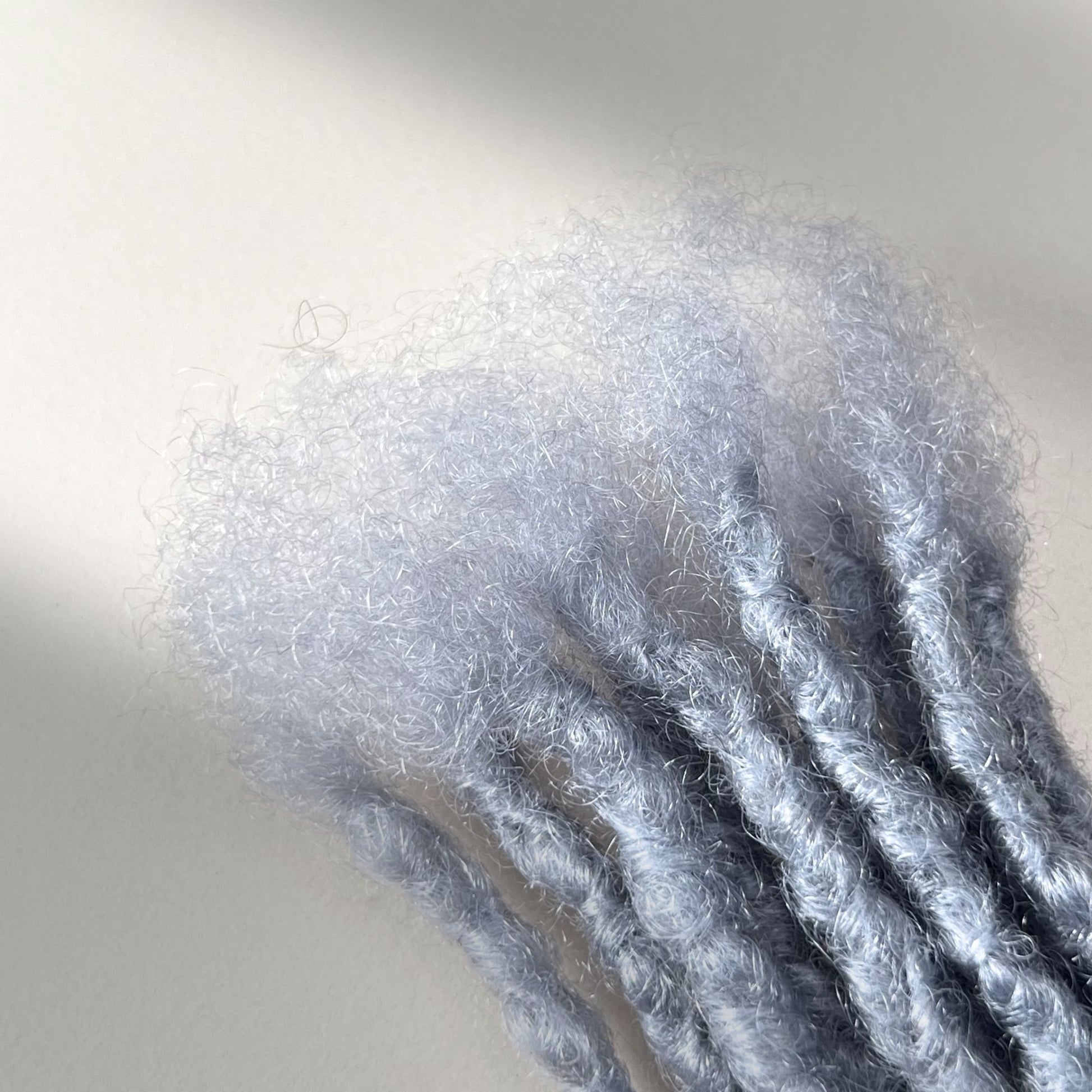 Close-up of the connection point on Grey kinky human hair loc extensions.