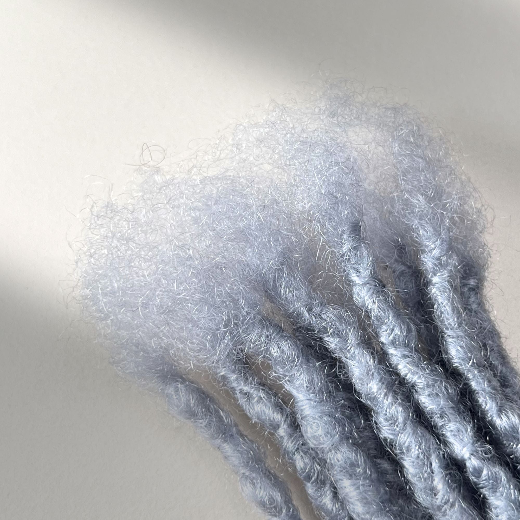 Close-up of the connection point on Grey kinky human hair loc extensions.