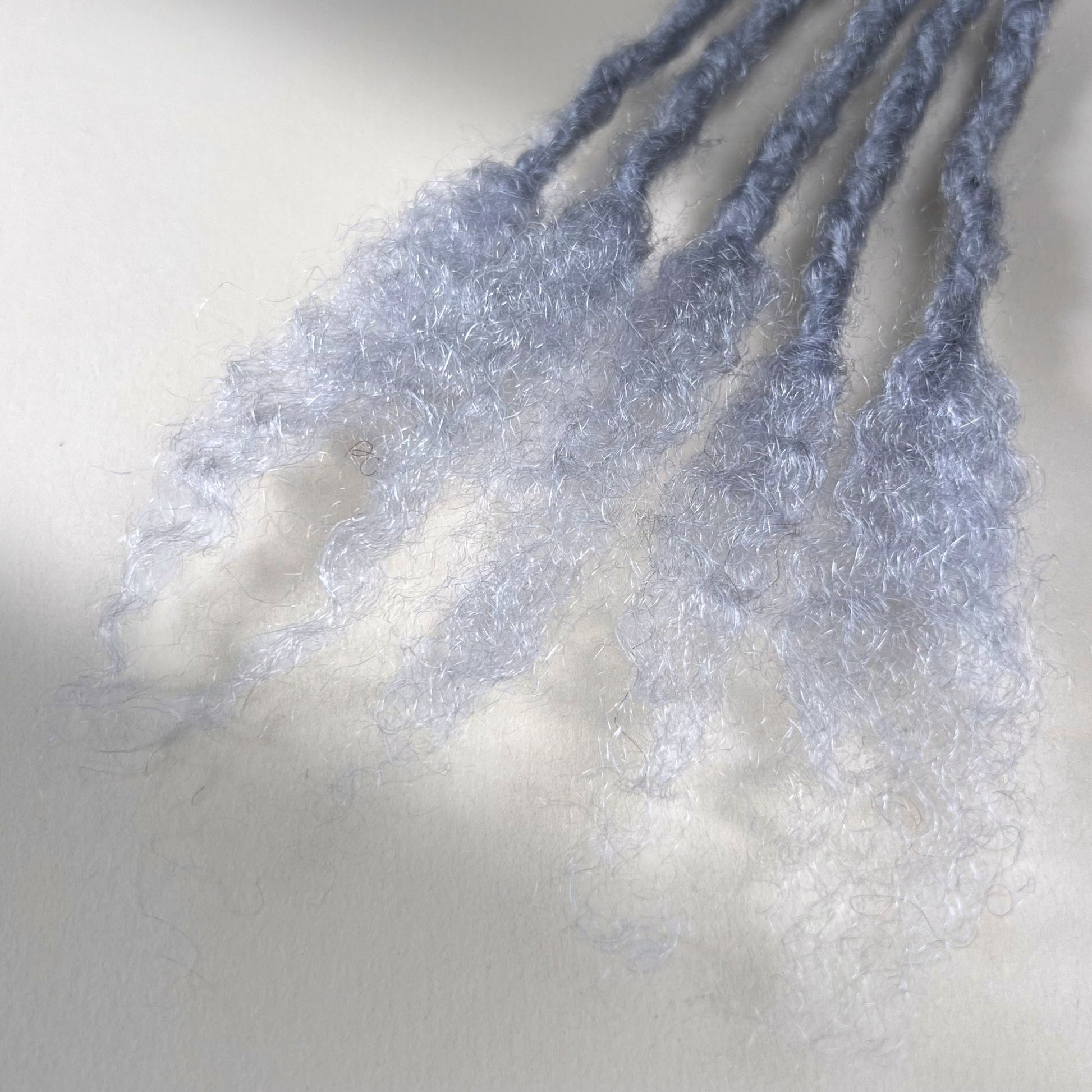 Close-up of the open ends on Grey kinky human hair loc extensions.