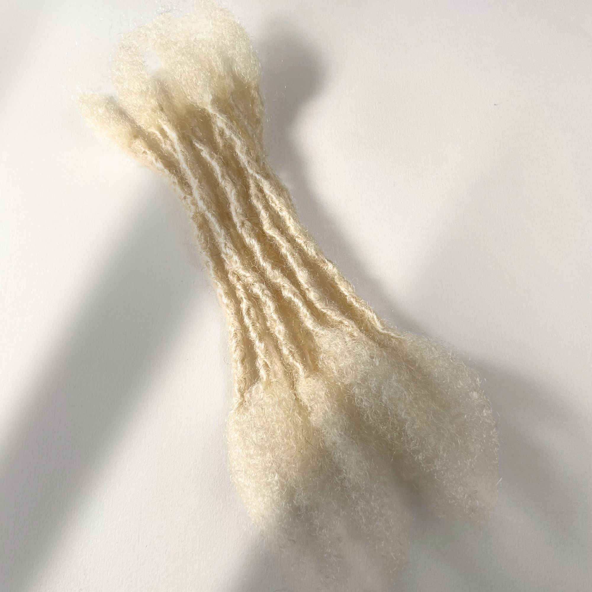 Bleach Blonde kinky human hair open end loc extensions made using the interlocking method.