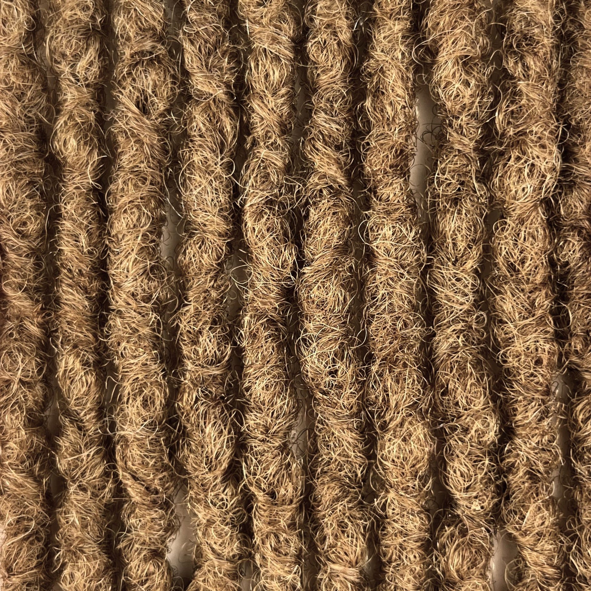Close-up of kinky loc extensions in Honey Blonde, showing the texture and color.