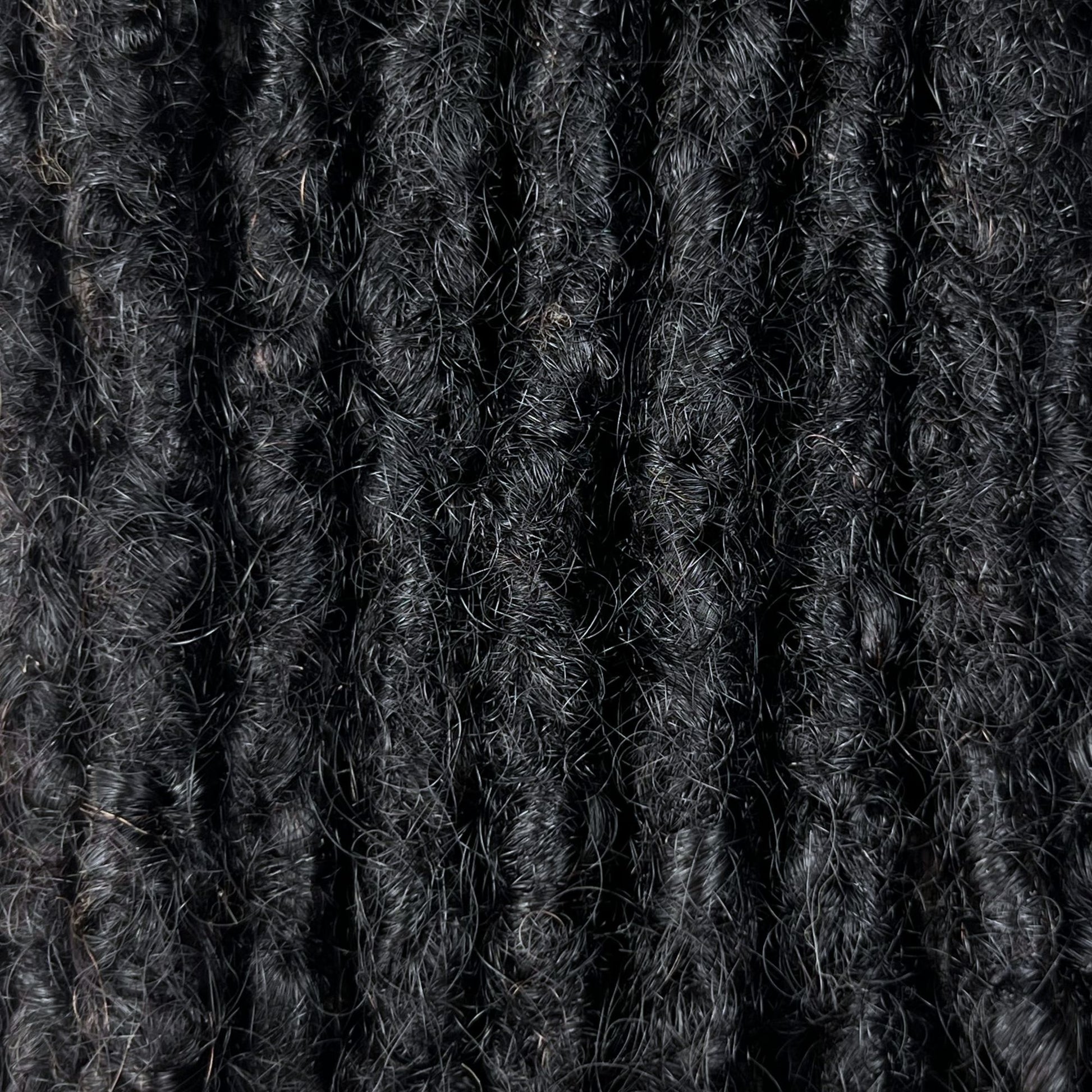Close-up of kinky loc extensions in Natural Black, showing the texture and color.