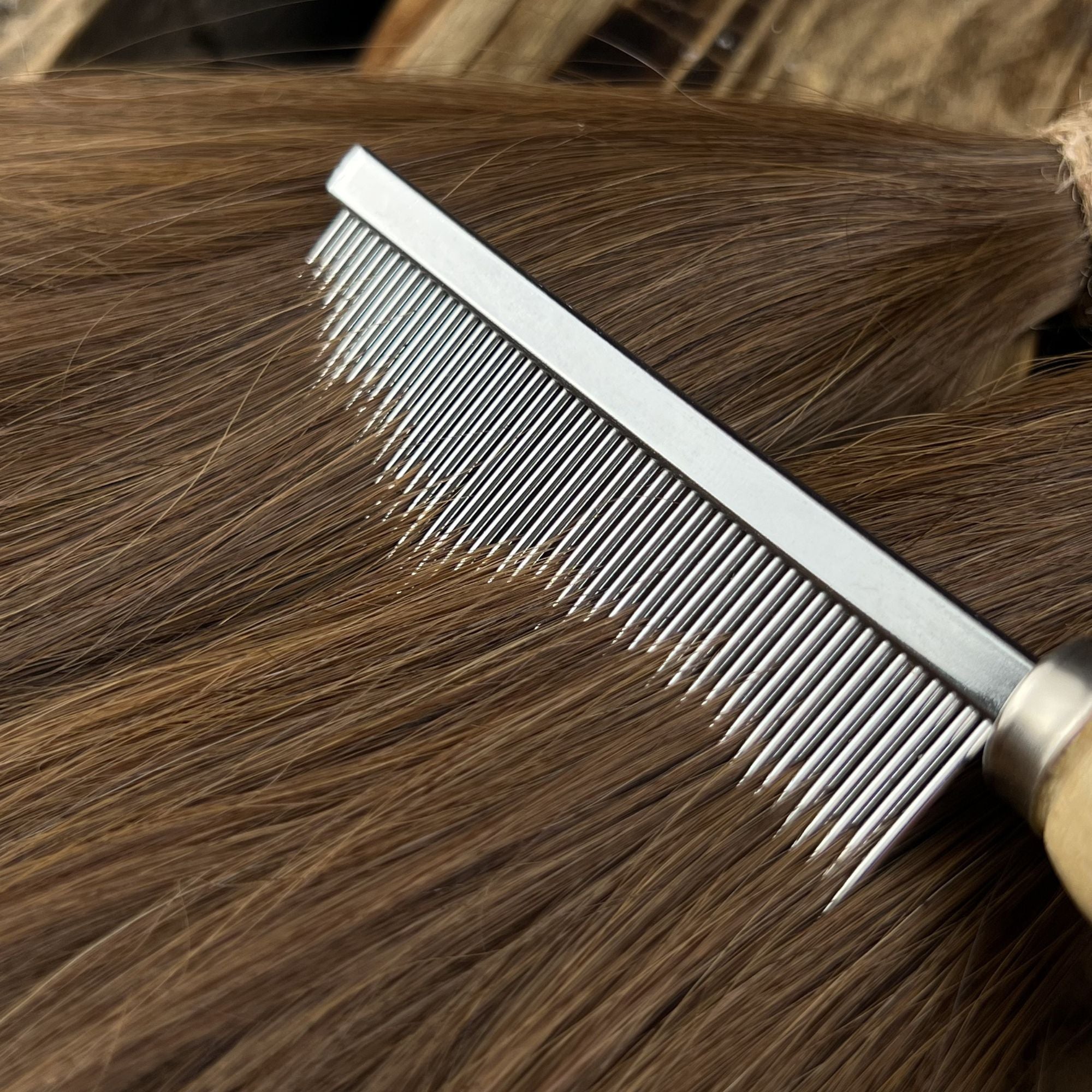 Close-up of the Loc Comb gliding through straight human hair to detangle and prepare hair for handcrafted Loc creation.