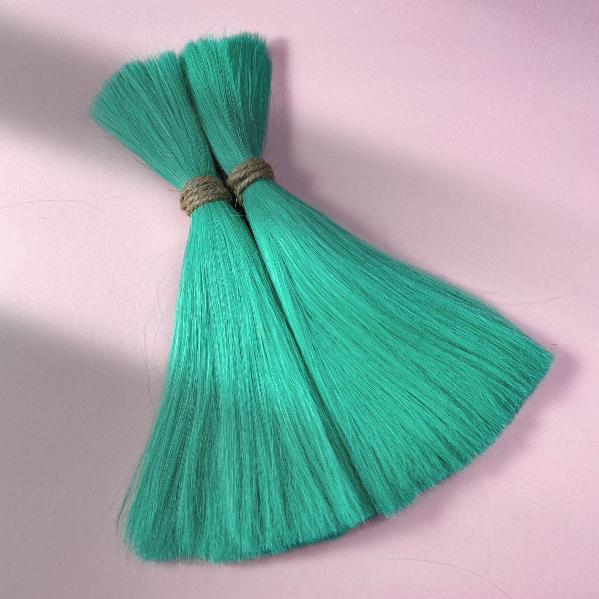 Full view of straight human hair in Pastel Emerald Green.