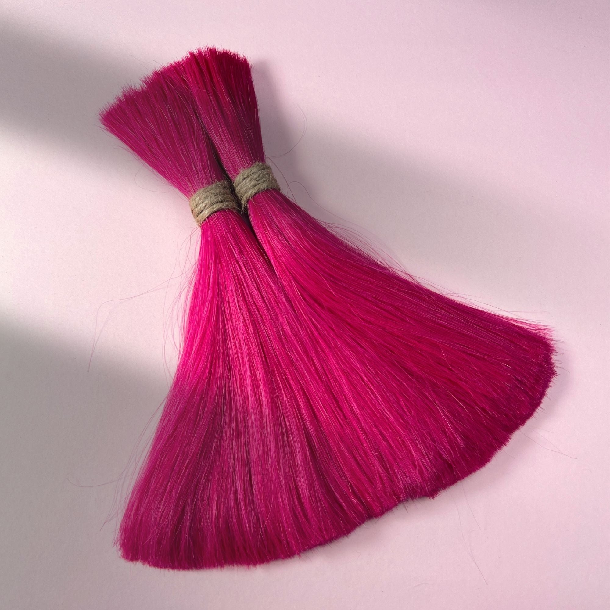 Full view of straight human hair in Magenta Pink.
