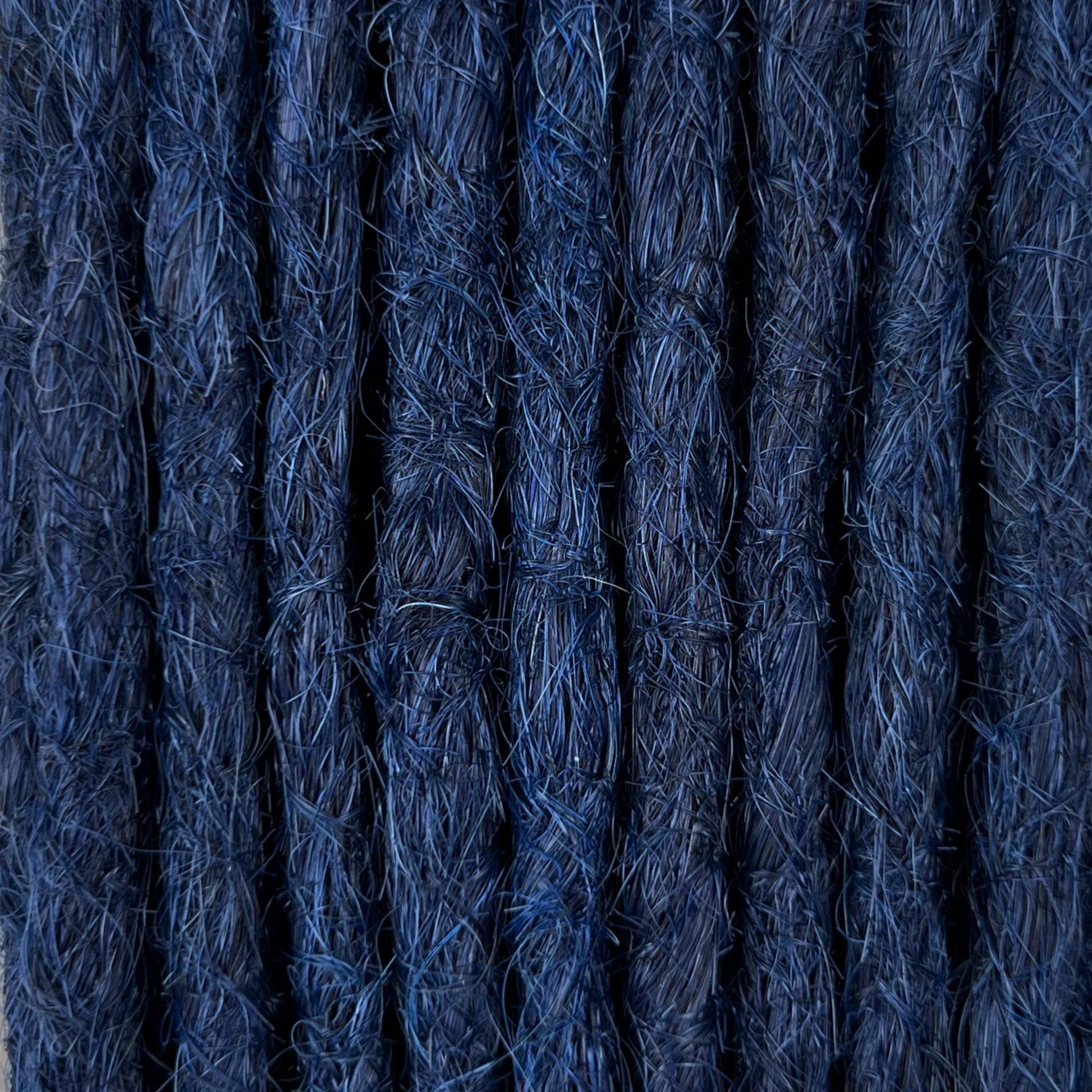 Close-up of straight loc extensions in Midnight Blue, showing the texture and color.