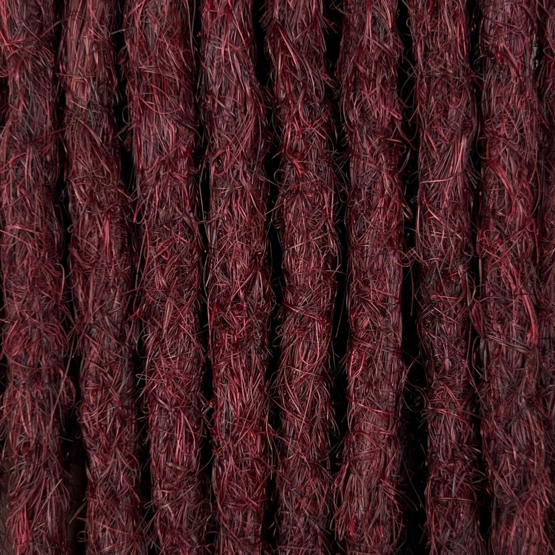 Close-up of straight loc extensions in Rich Burgundy Red, showing the texture and color.