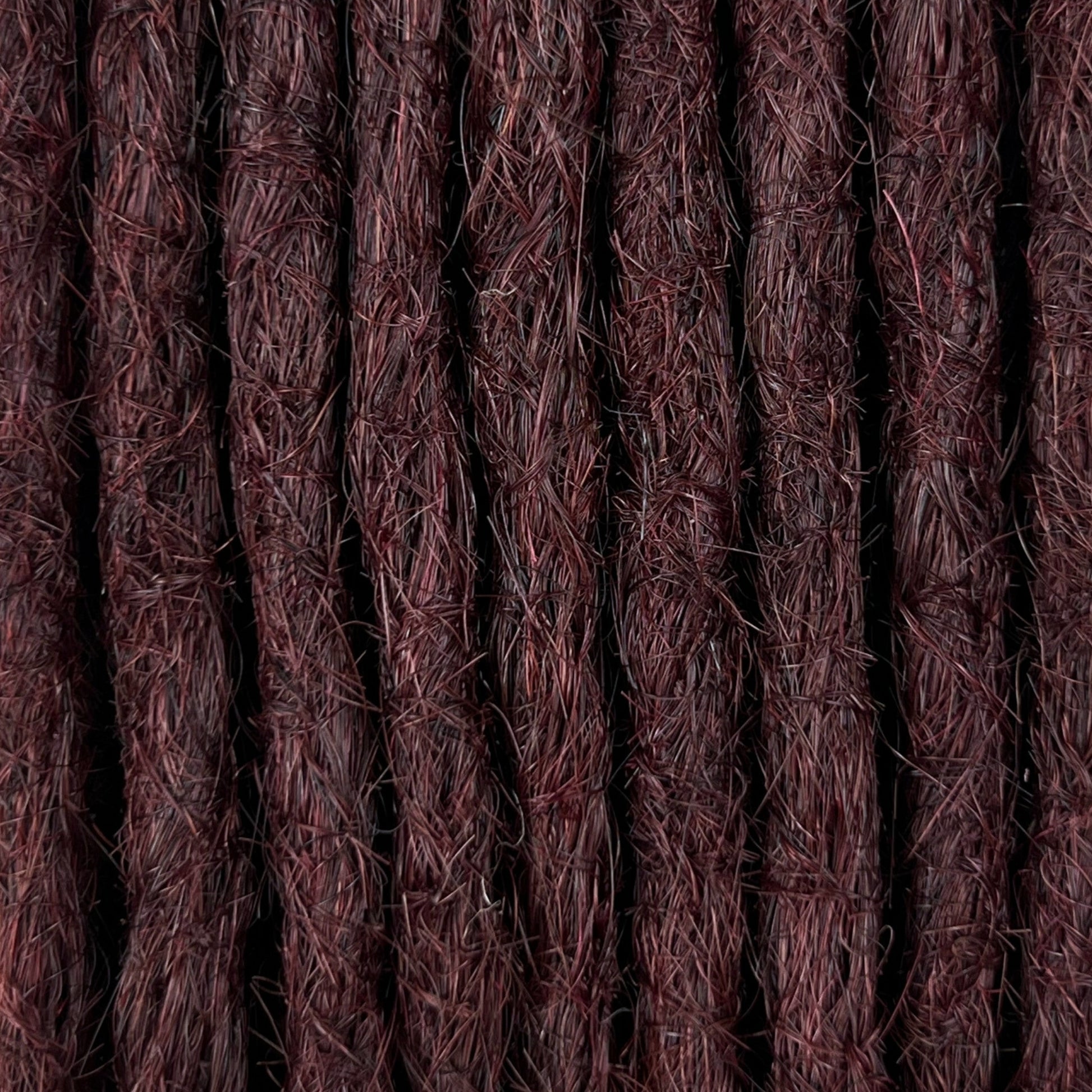 Close-up of straight loc extensions in Deep Crimson Red, showing the texture and color.