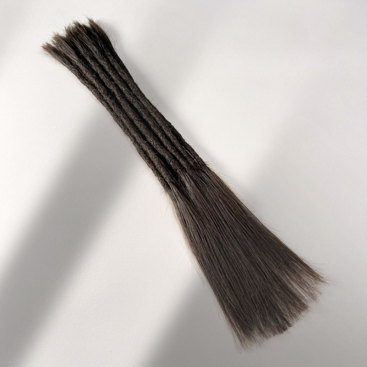 Full view of permanent straight loc extensions with long loose ends in Dark Wenge Brown.