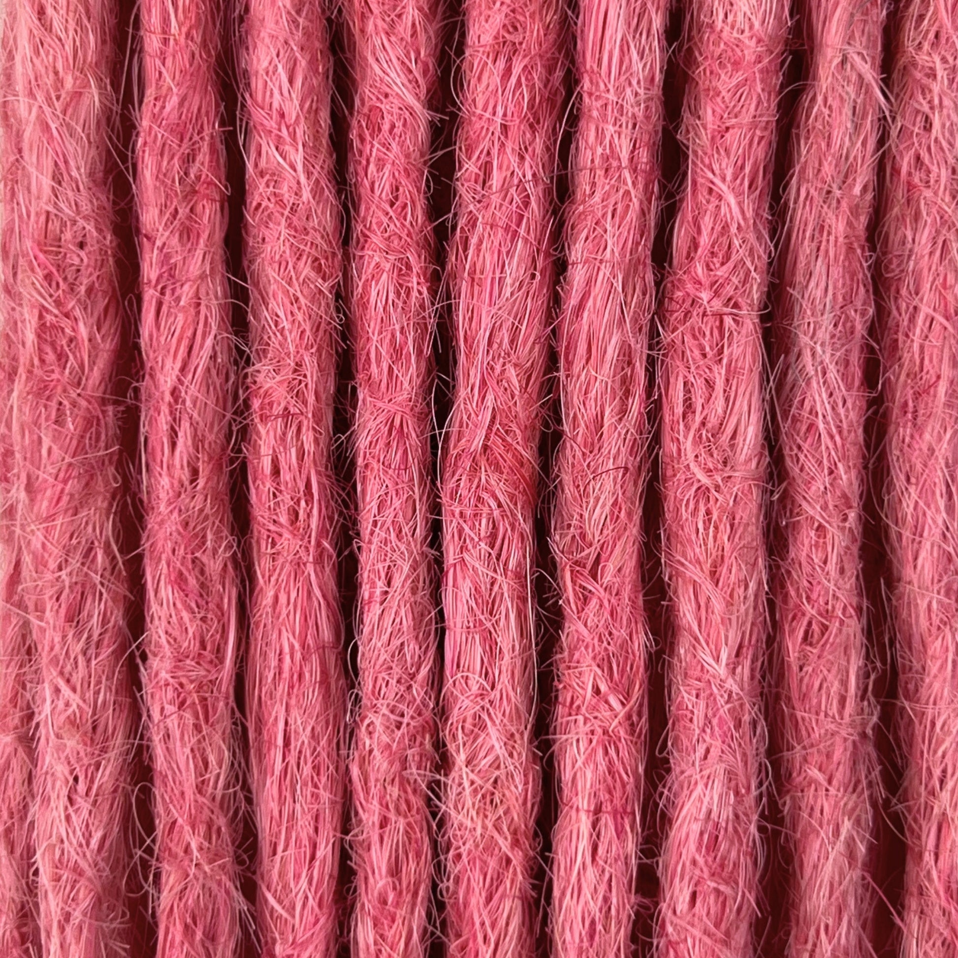 Close-up of straight loc extensions in Bubblegum Pink, showing the texture and color.