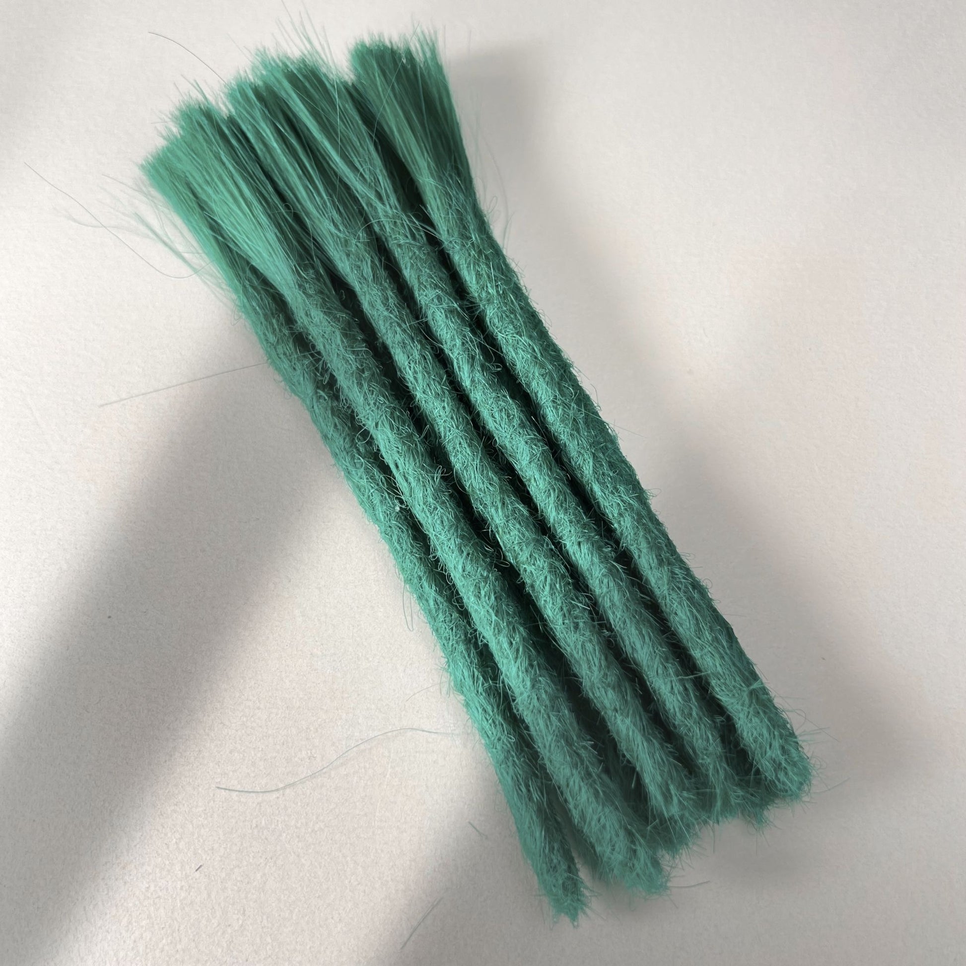 Full view of permanent straight loc extensions with blunt ends in Emerald Green.