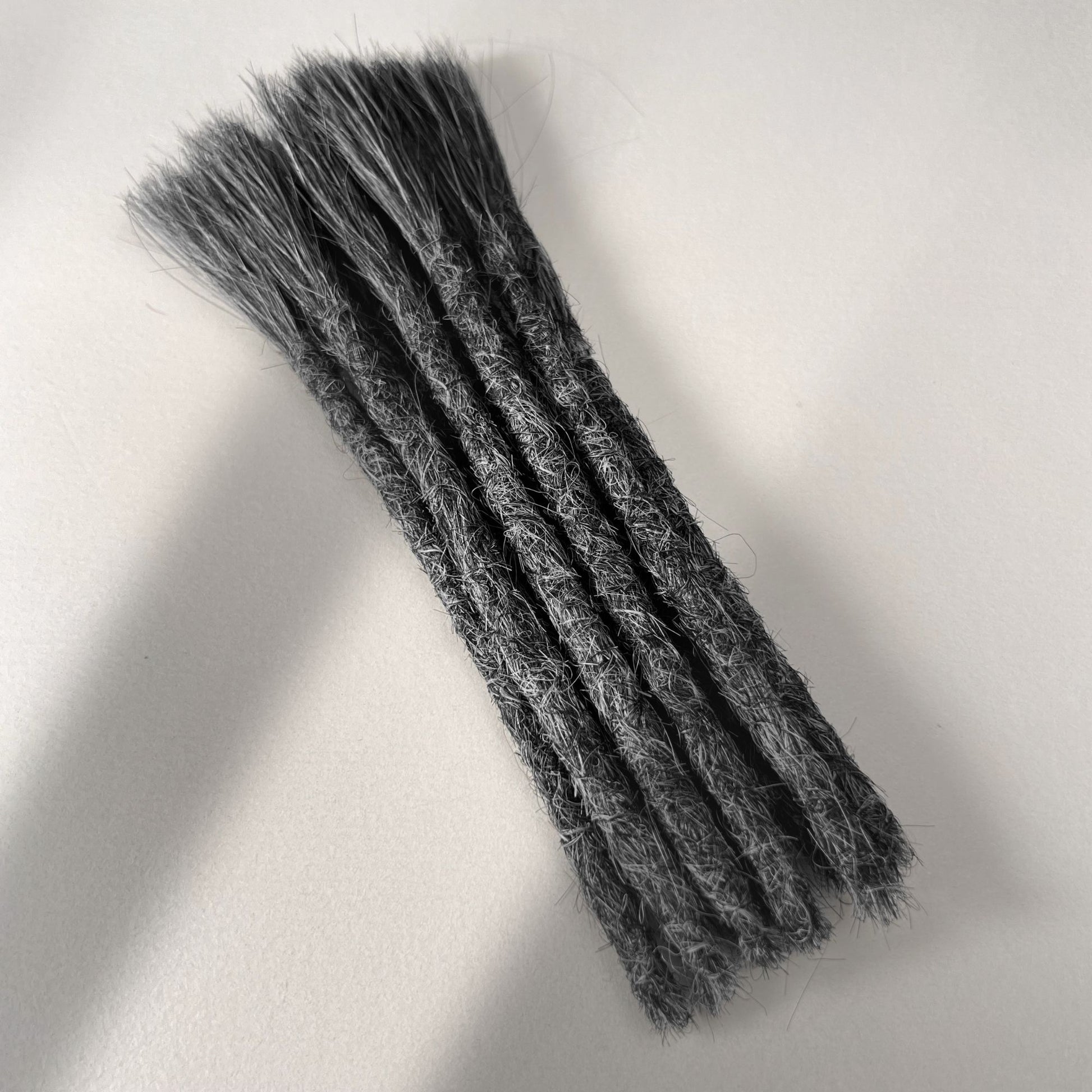 Full view of permanent straight loc extensions with blunt ends in Steel Silver.