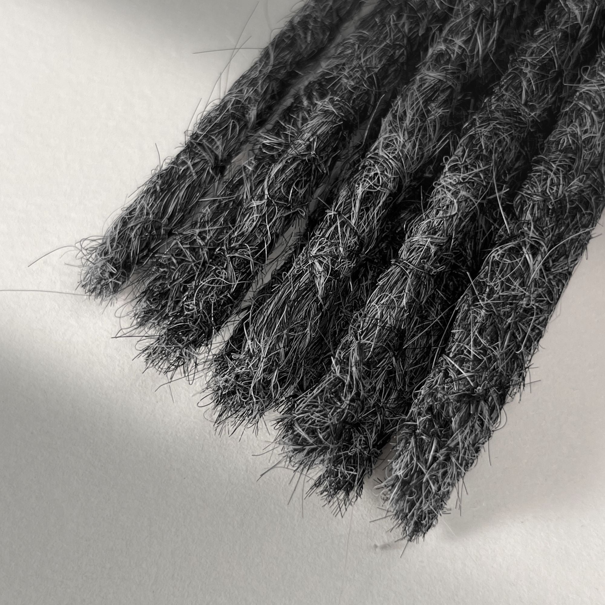 Tip detail of straight loc extensions with blunt ends in Steel Silver.
