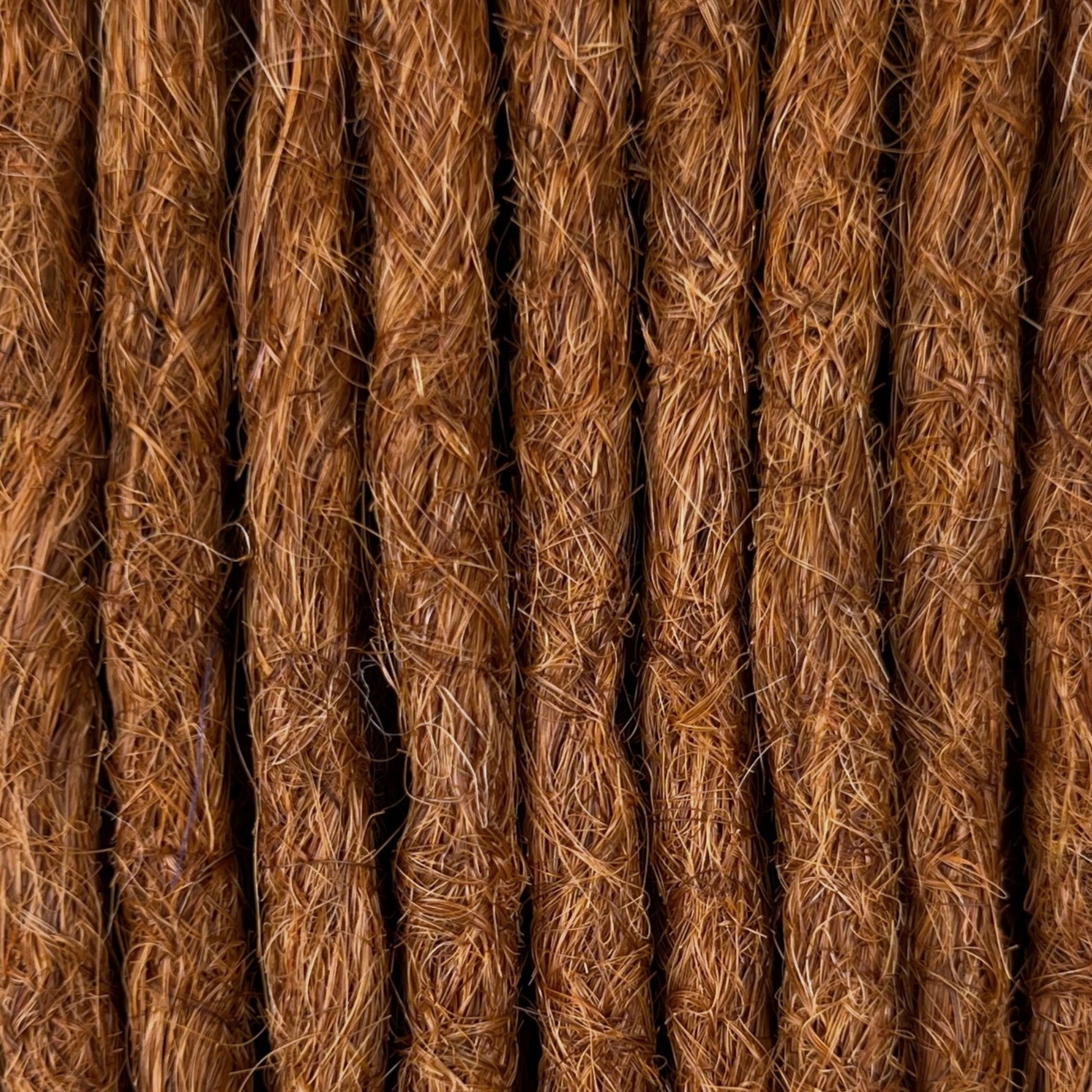 Close-up of straight loc extensions in Burnt Copper, showing the texture and color.