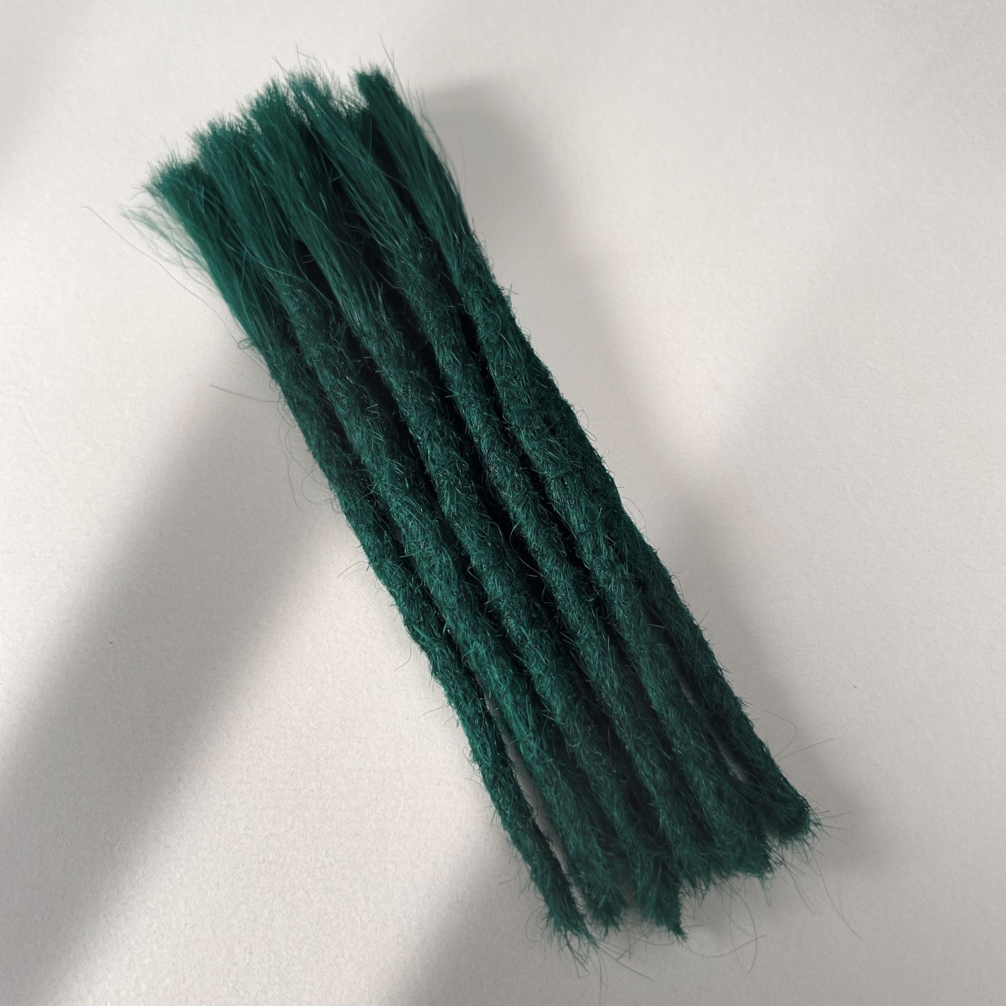Full view of permanent straight loc extensions with blunt ends in Forest Green.