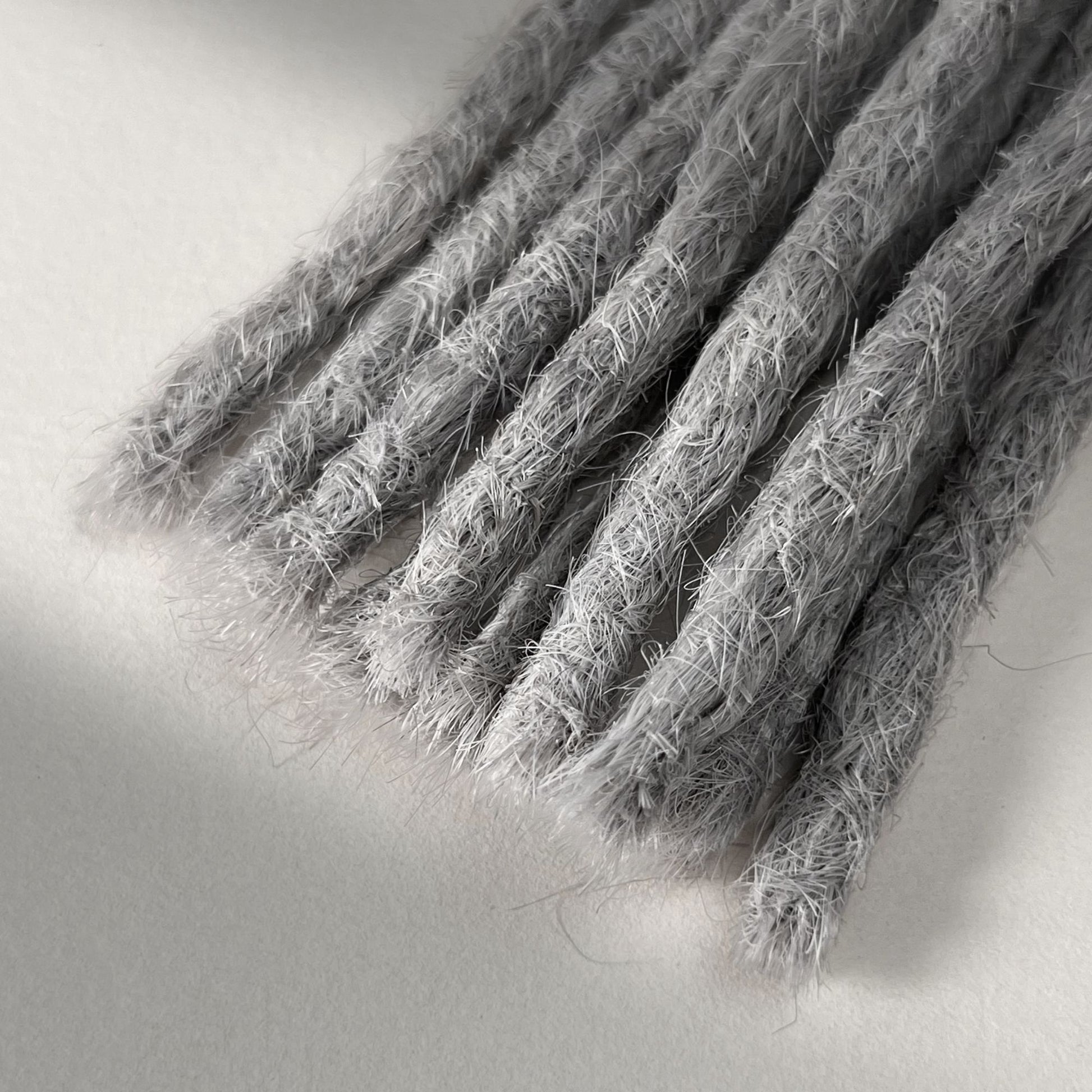 Tip detail of straight loc extensions with blunt ends in Pearl Silver.