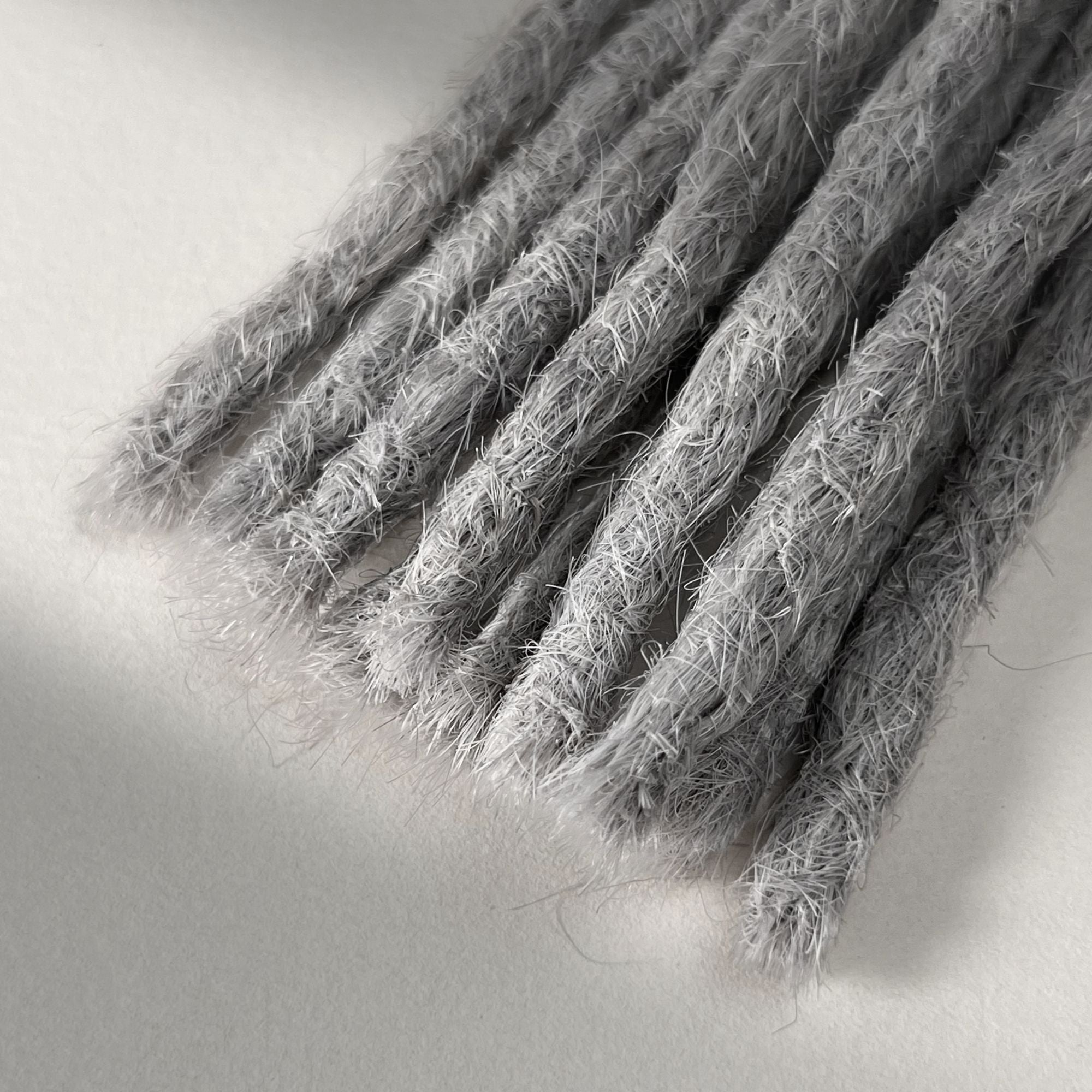 Tip detail of straight loc extensions with blunt ends in Pearl Silver.