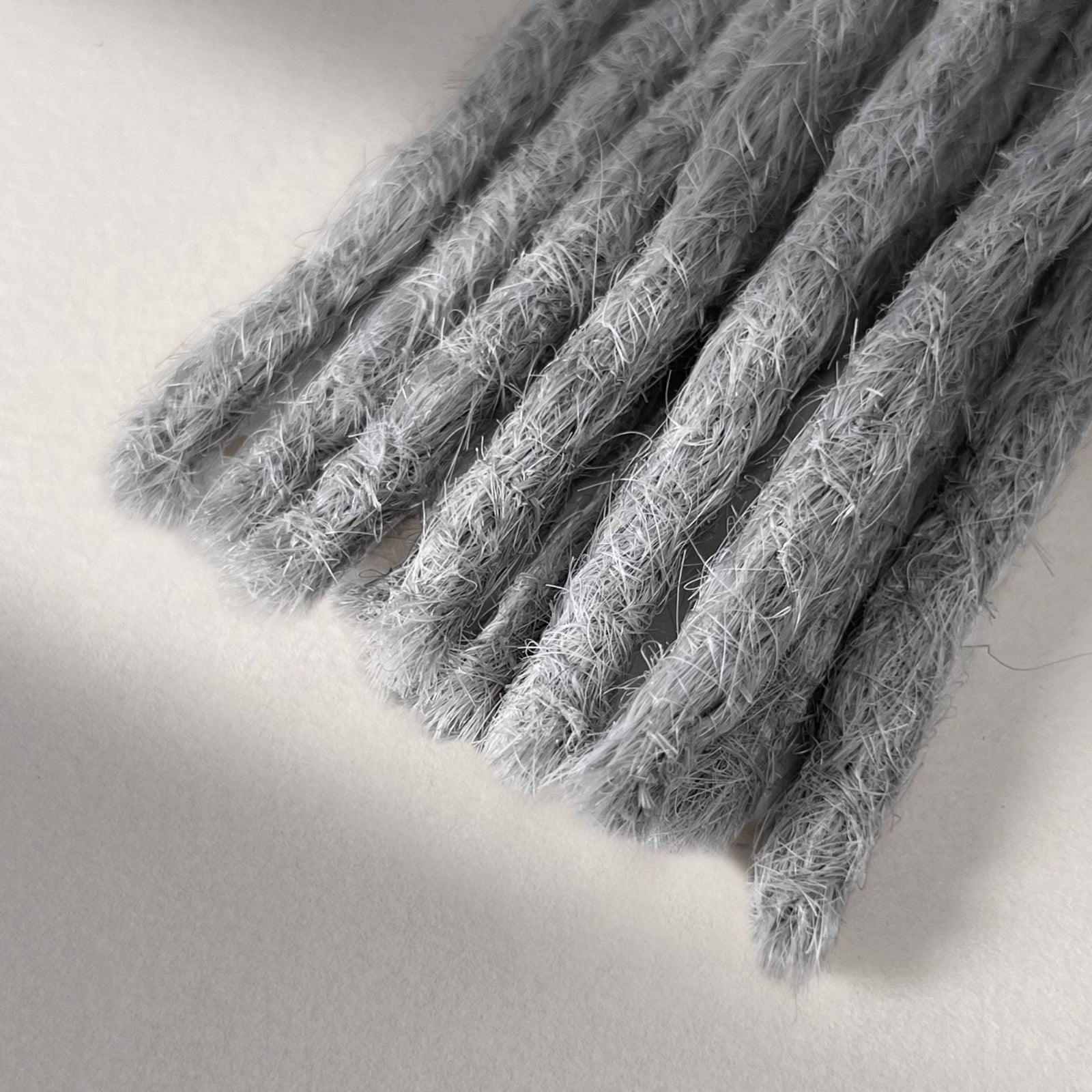 Tip detail of straight loc extensions with blunt ends in Pearl Silver.