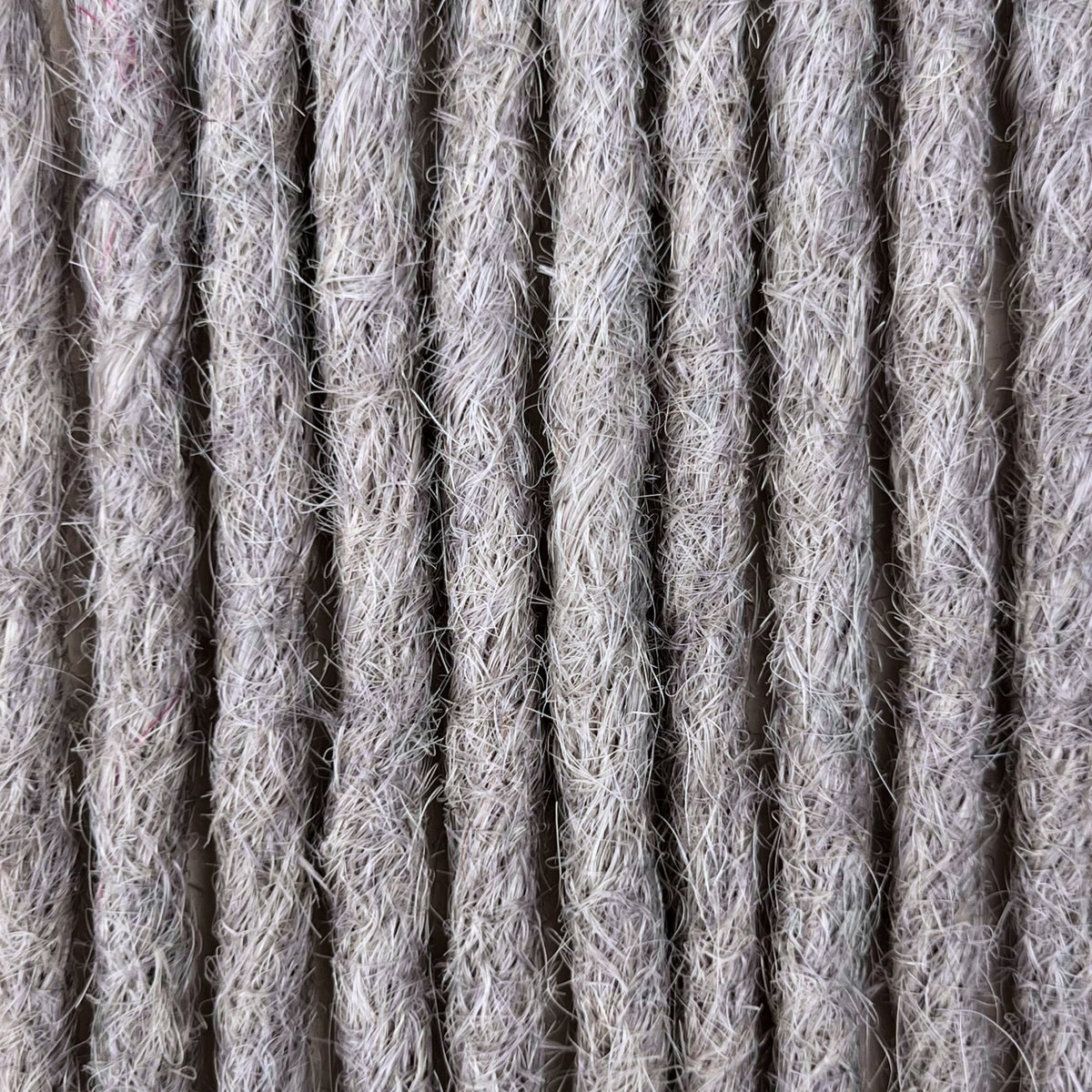 Close-up of straight loc extensions in Pearl Silver, showing the texture and color.