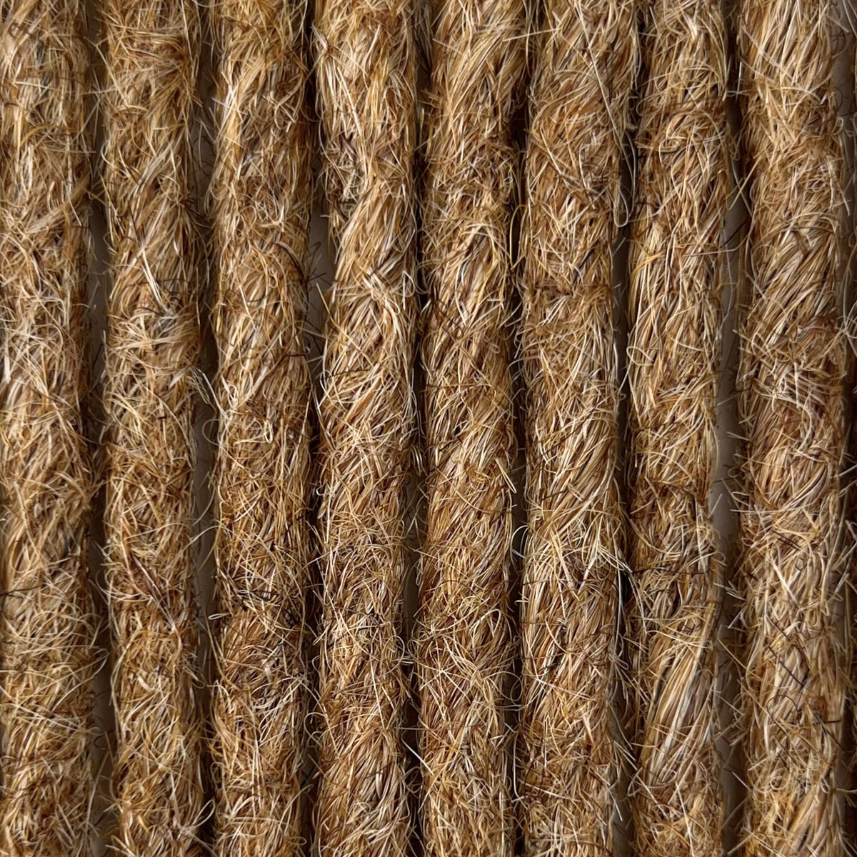 Close-up of straight loc extensions in Honey Blonde, showing the texture and color.