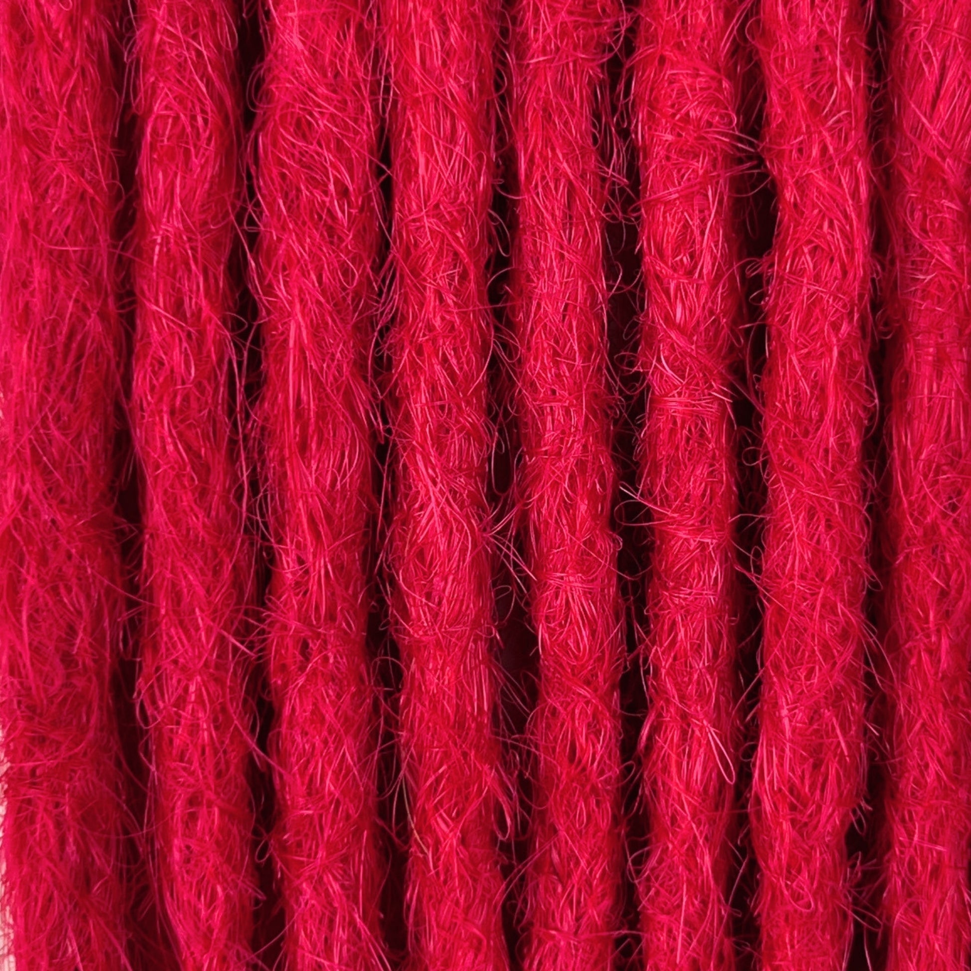 Close-up of straight loc extensions in Indian Pink, showing the texture and color.