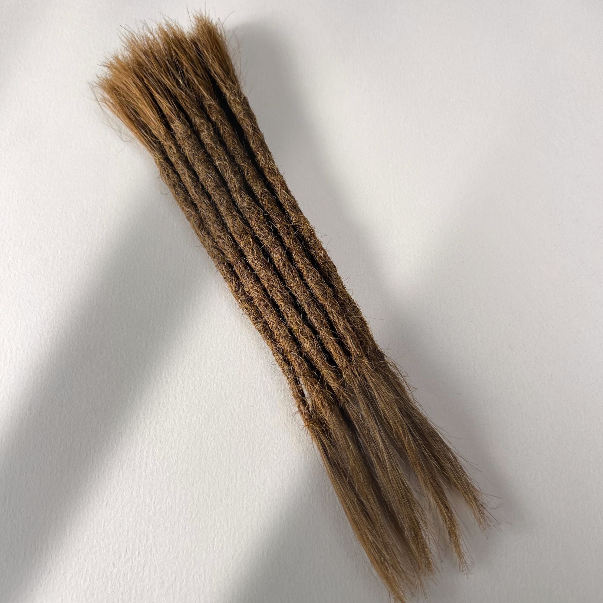 Full view of permanent straight loc extensions with open ends in Honey Brown.