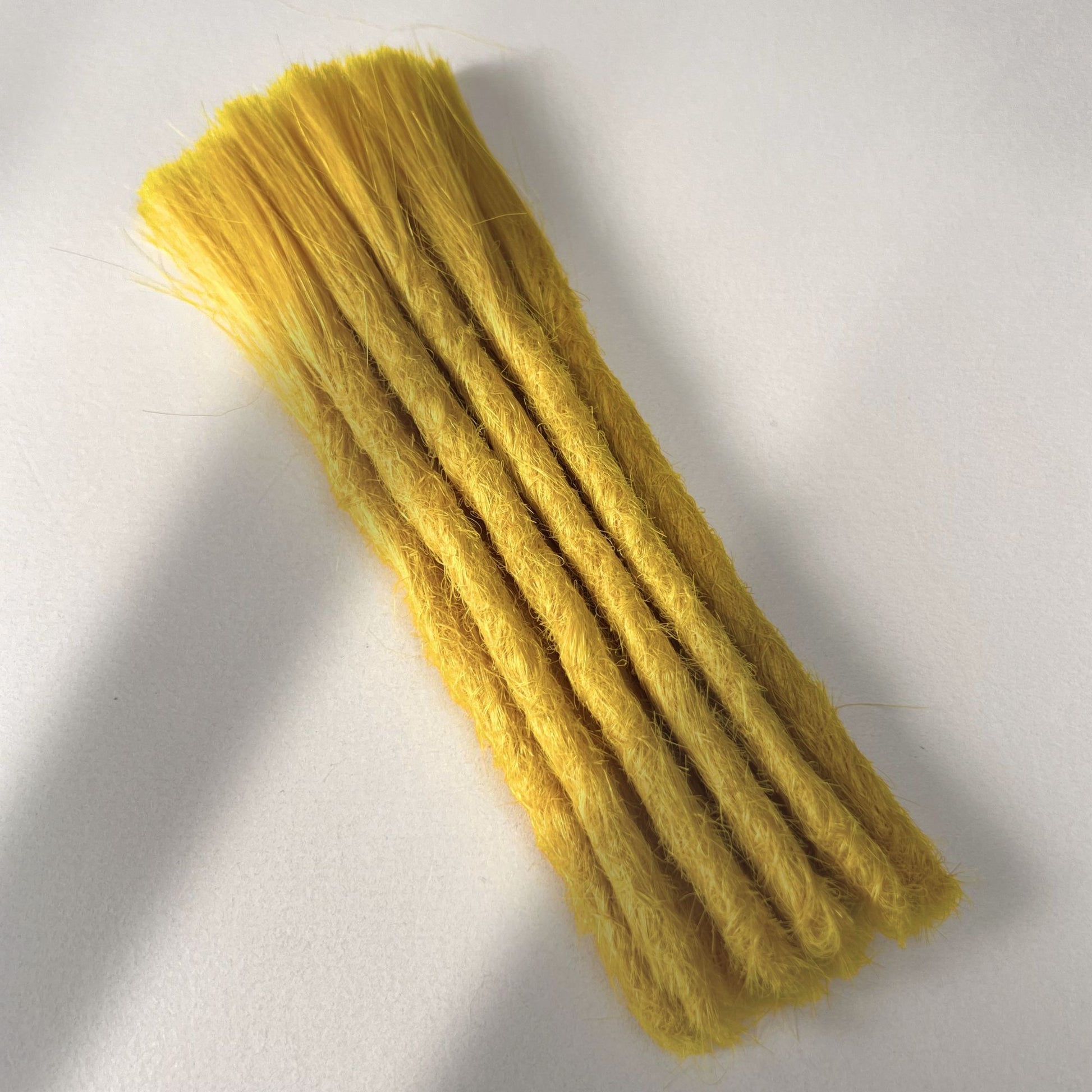 Full view of permanent straight loc extensions with blunt ends in Lemon Yellow.