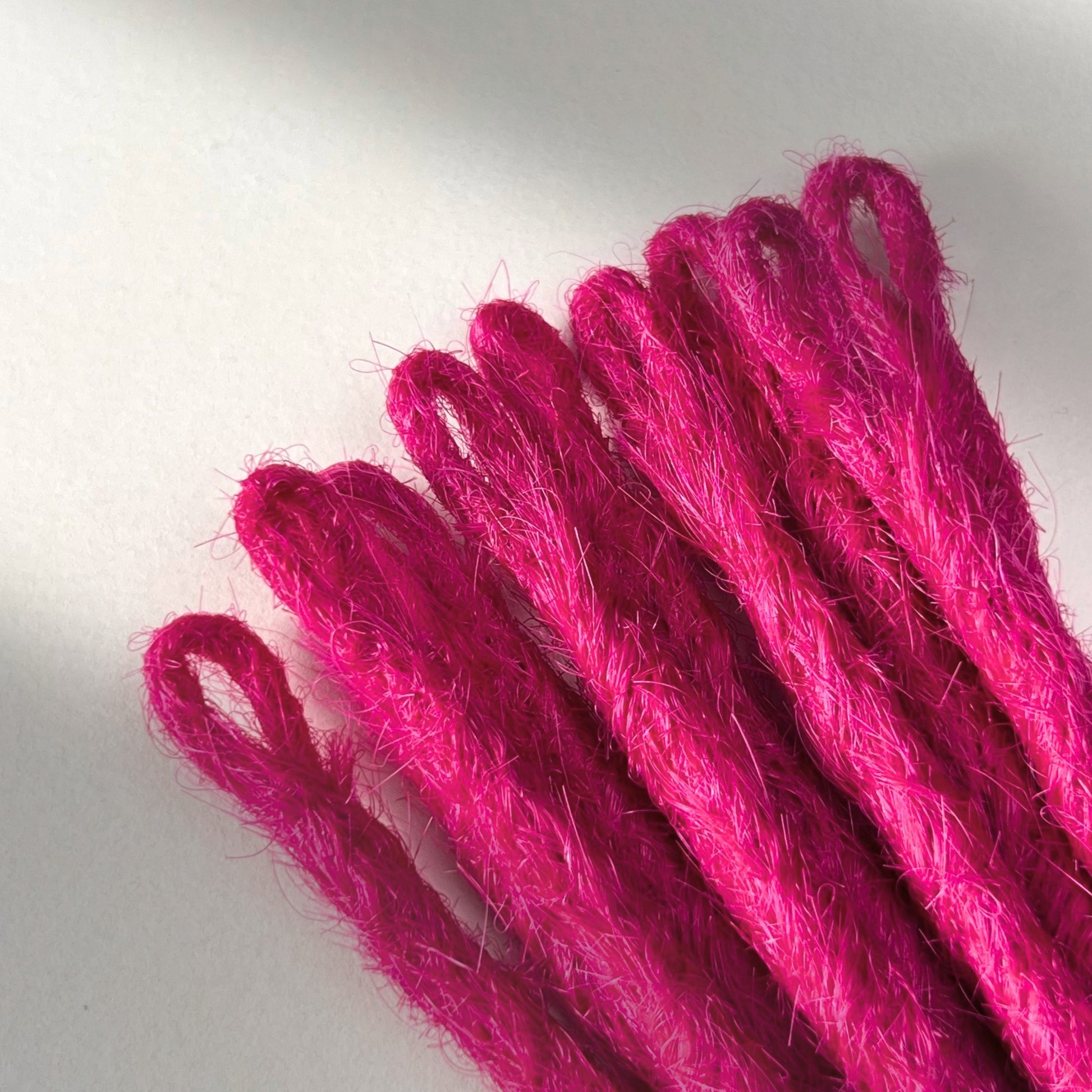 Loop detail of temporary single-ended straight loc extensions in Magenta Pink.