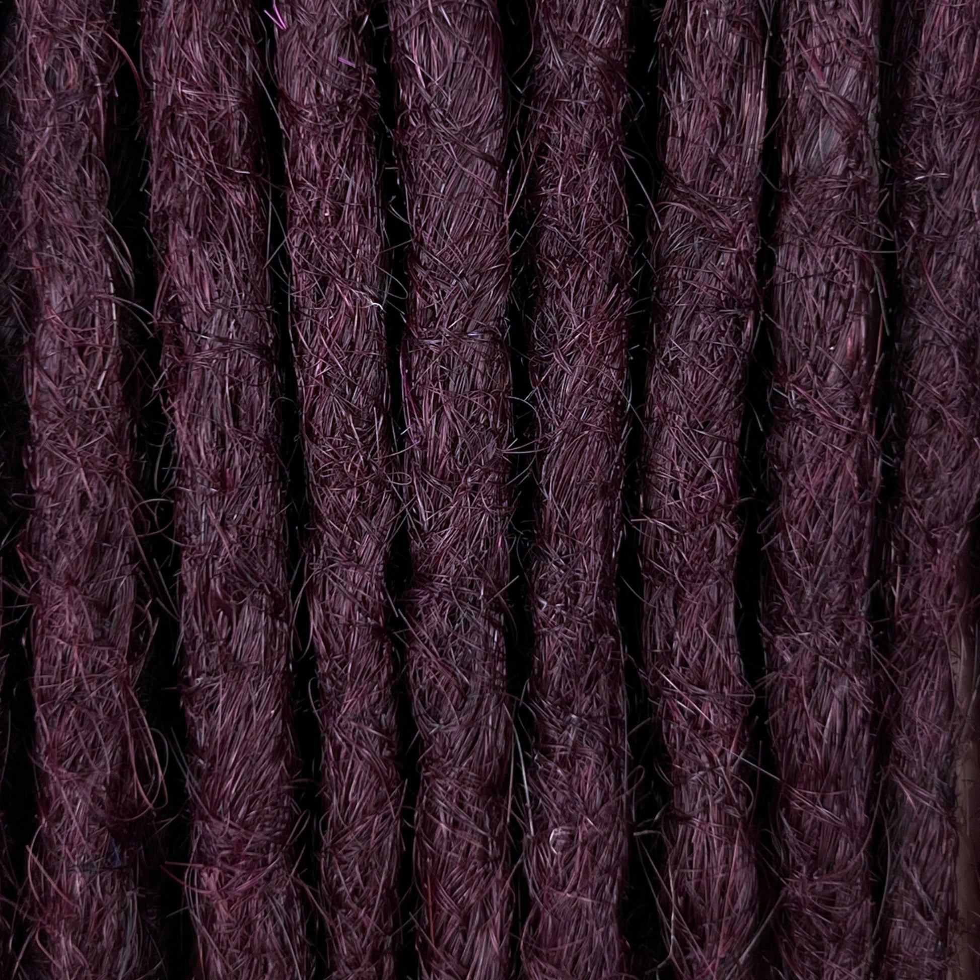 Close-up of straight loc extensions in Warm Marsala Red, showing the texture and color.