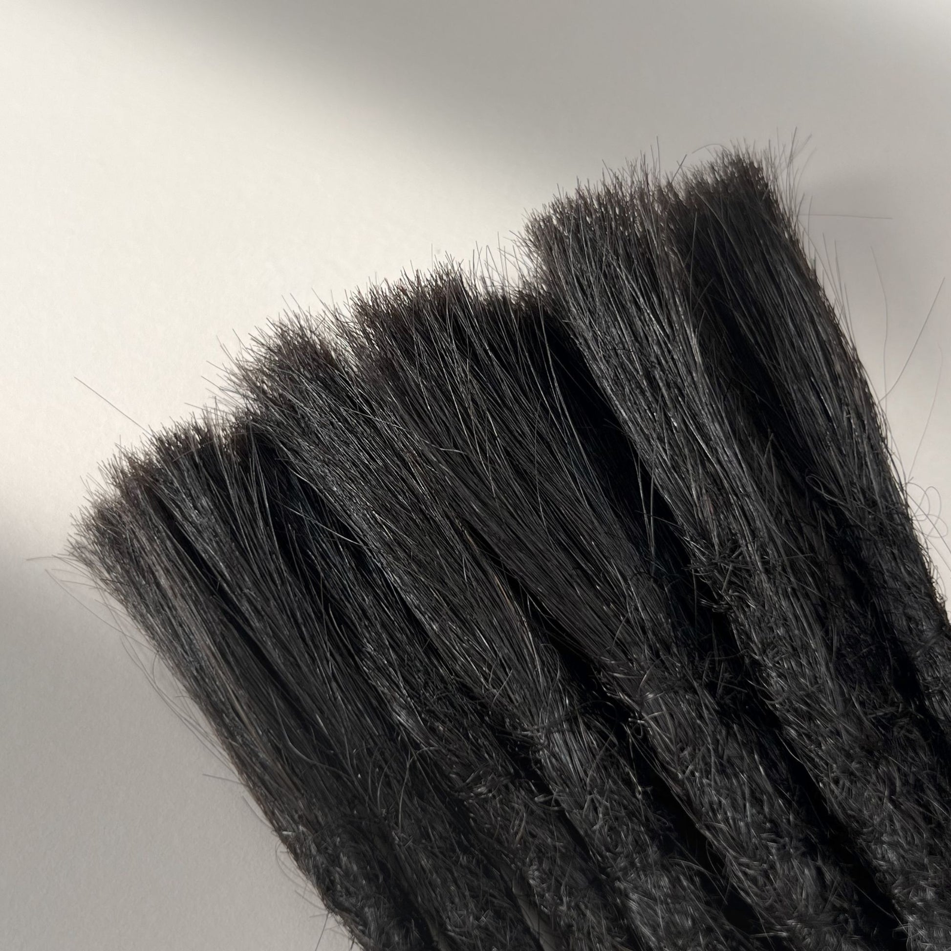 Connection point of permanent straight loc extensions with open ends in Dark Ash Brown.
