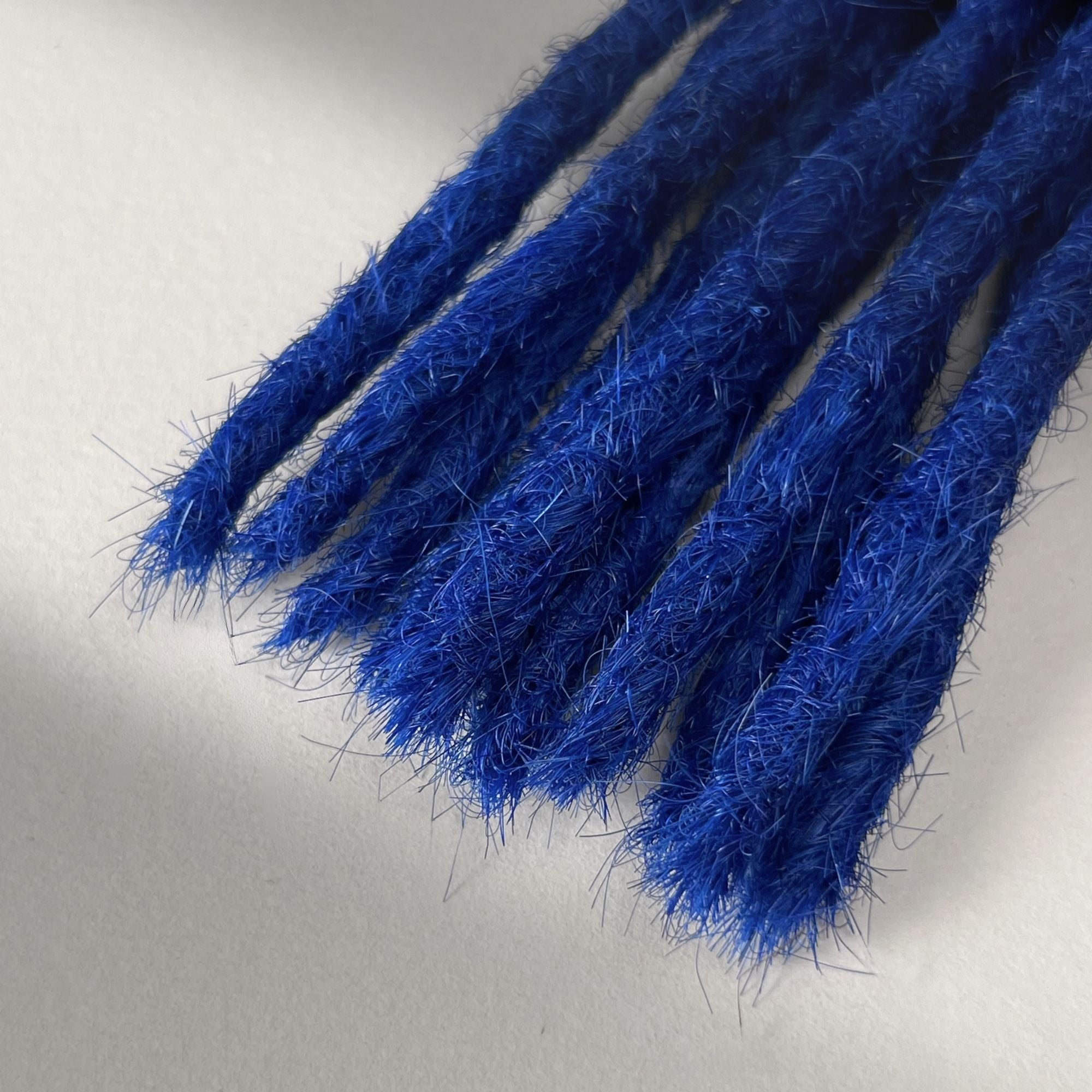 Tip detail of straight loc extensions with blunt ends in Deep Navy Blue.