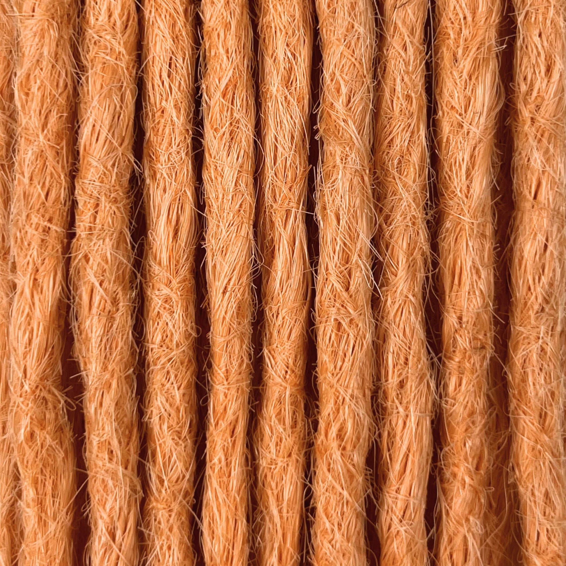 Close-up of straight loc extensions in Peach Orange, showing the texture and color.