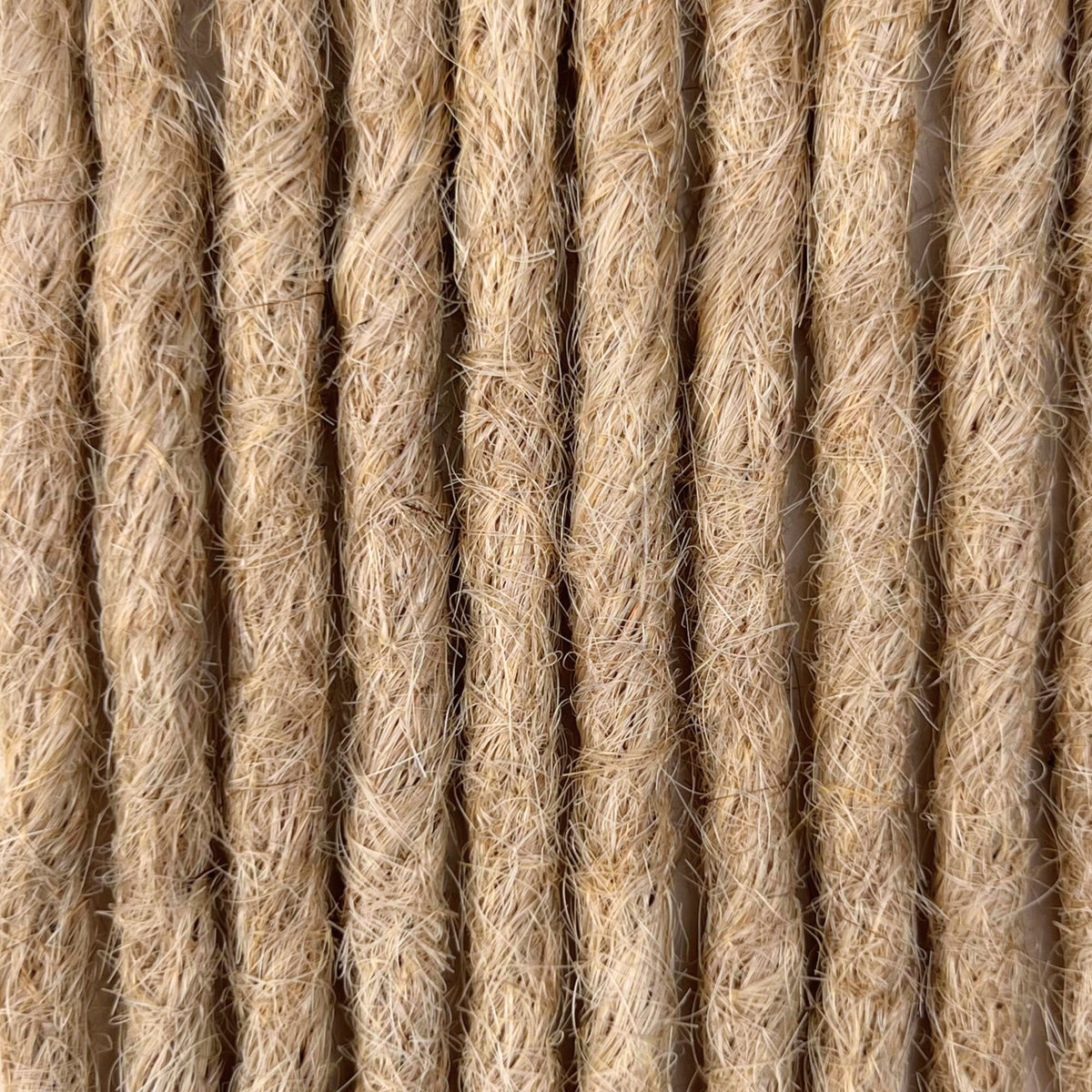 Close-up of straight loc extensions in Sunlit Blonde, showing the texture and color.