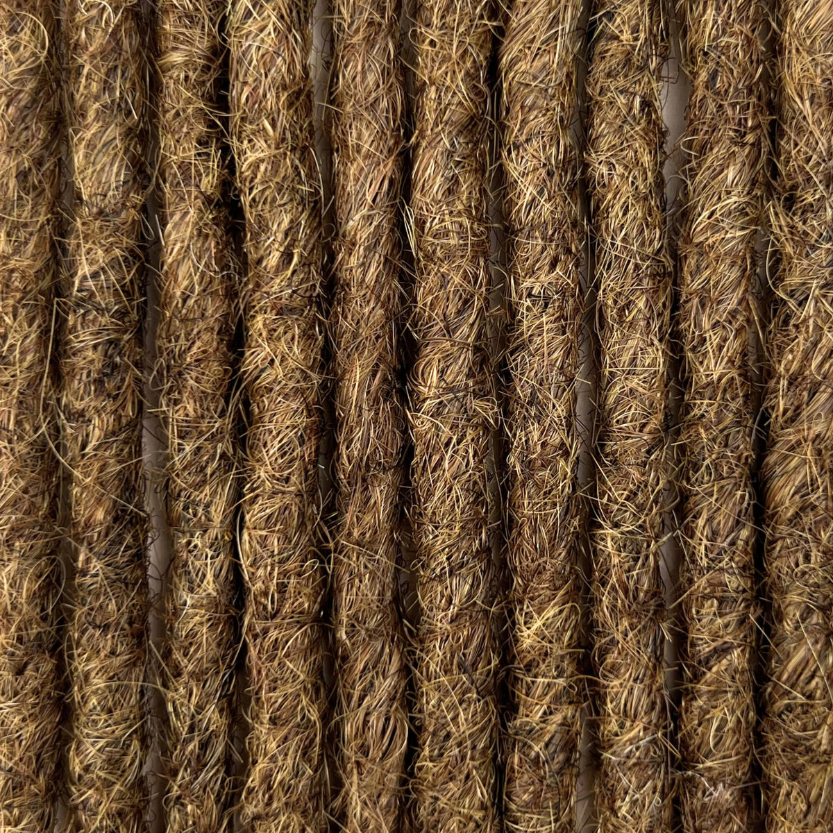 Close-up of straight loc extensions in Natural Medium Brown, showing the texture and color.