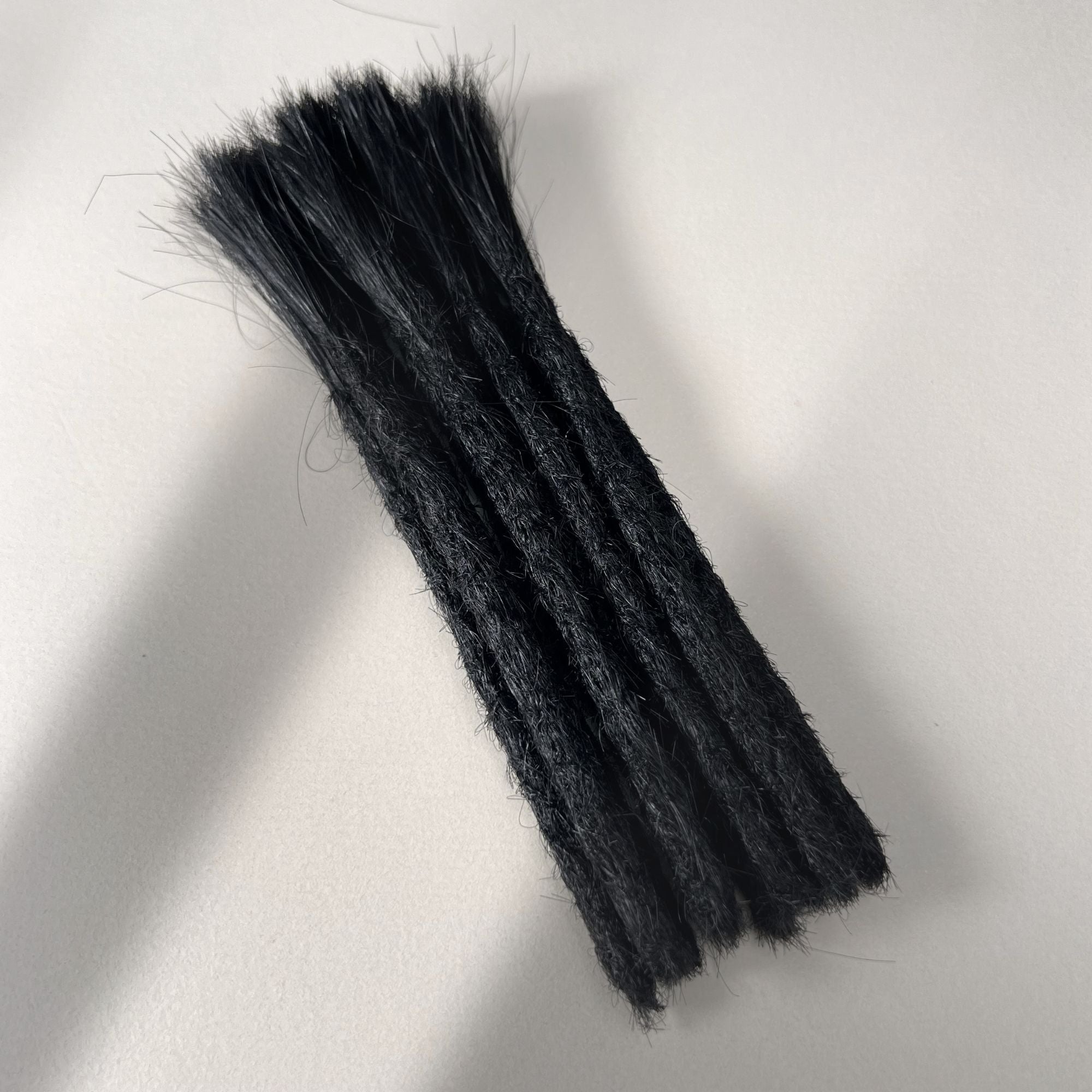 Full view of permanent straight loc extensions with blunt ends in Deepest Black.