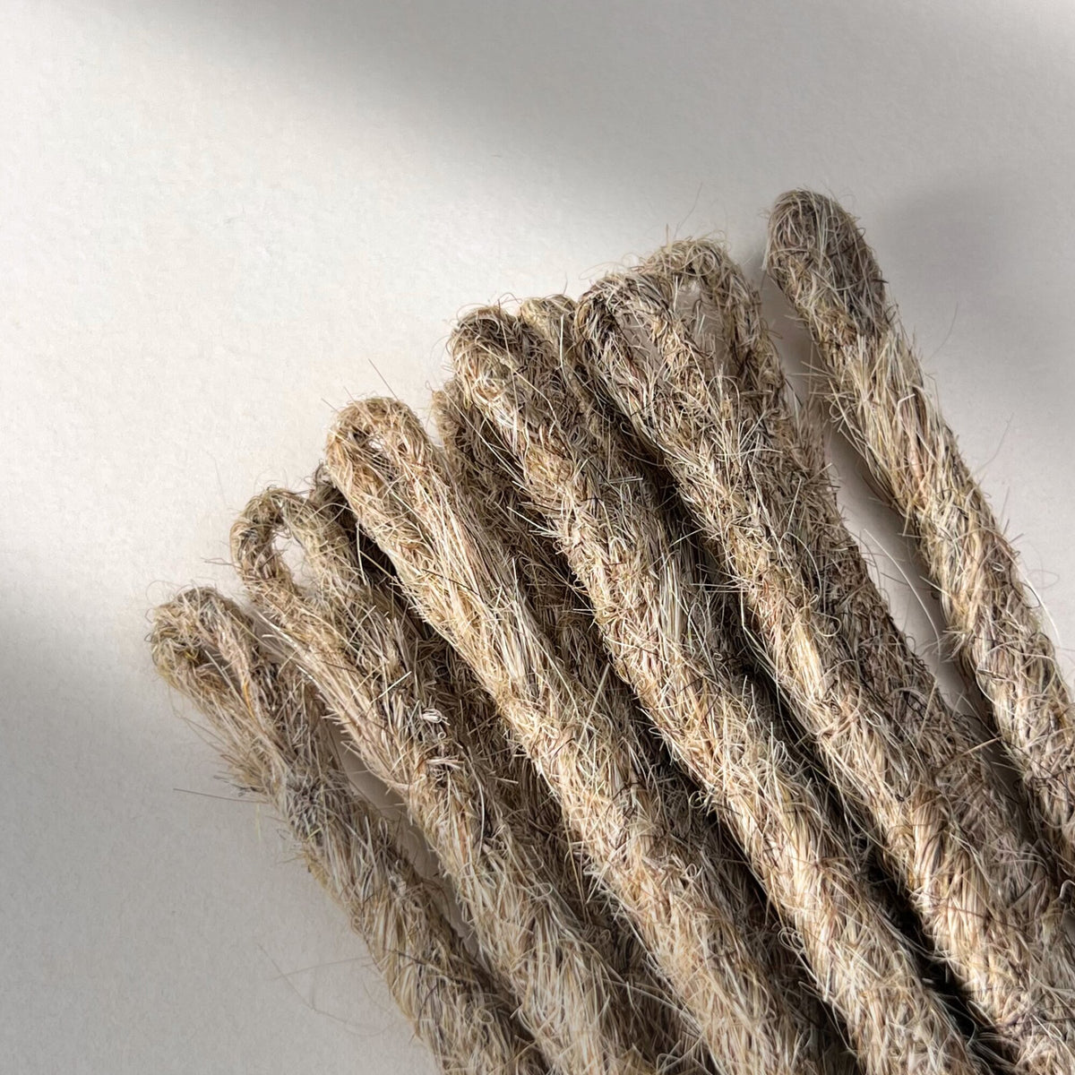 Close-up of the temporary loop connection point on handcrafted Straight Human Hair Loc Extensions in Sandy Blonde.
