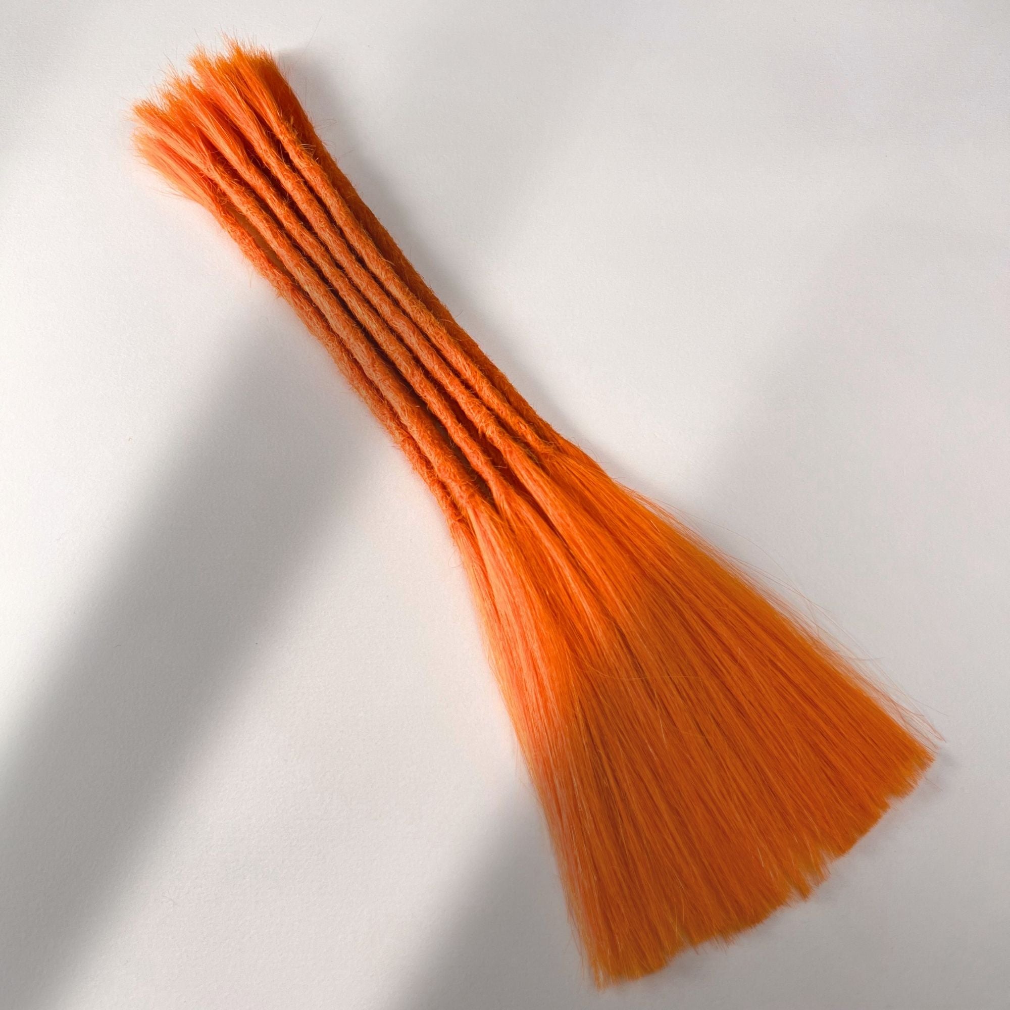 Full view of permanent straight loc extensions with long loose ends in Burnt Orange.