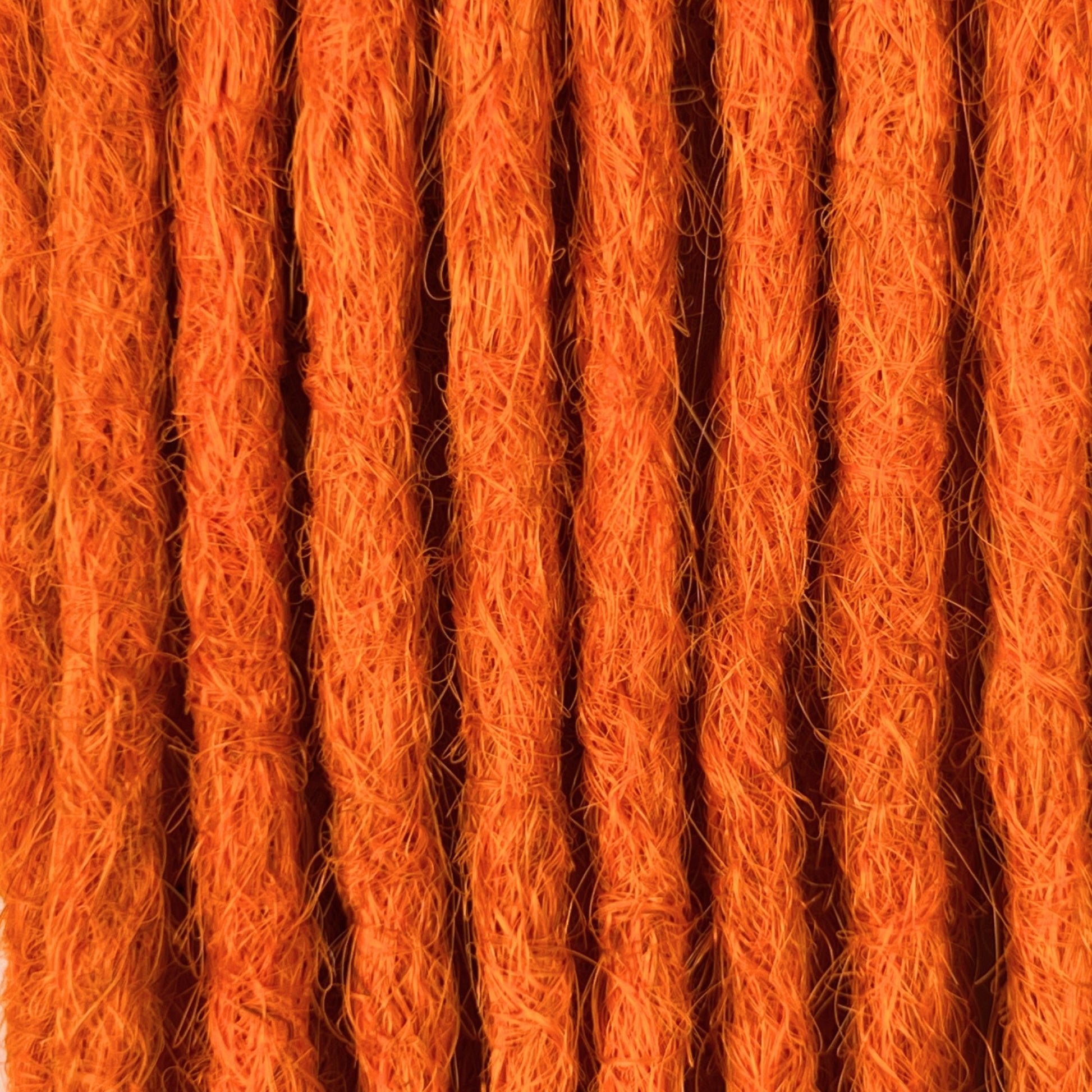 Close-up of straight loc extensions in Burnt Orange, showing the texture and color.