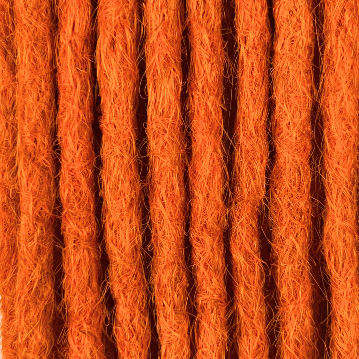 Close-up of straight loc extensions in Burnt Orange, showing the texture and color.