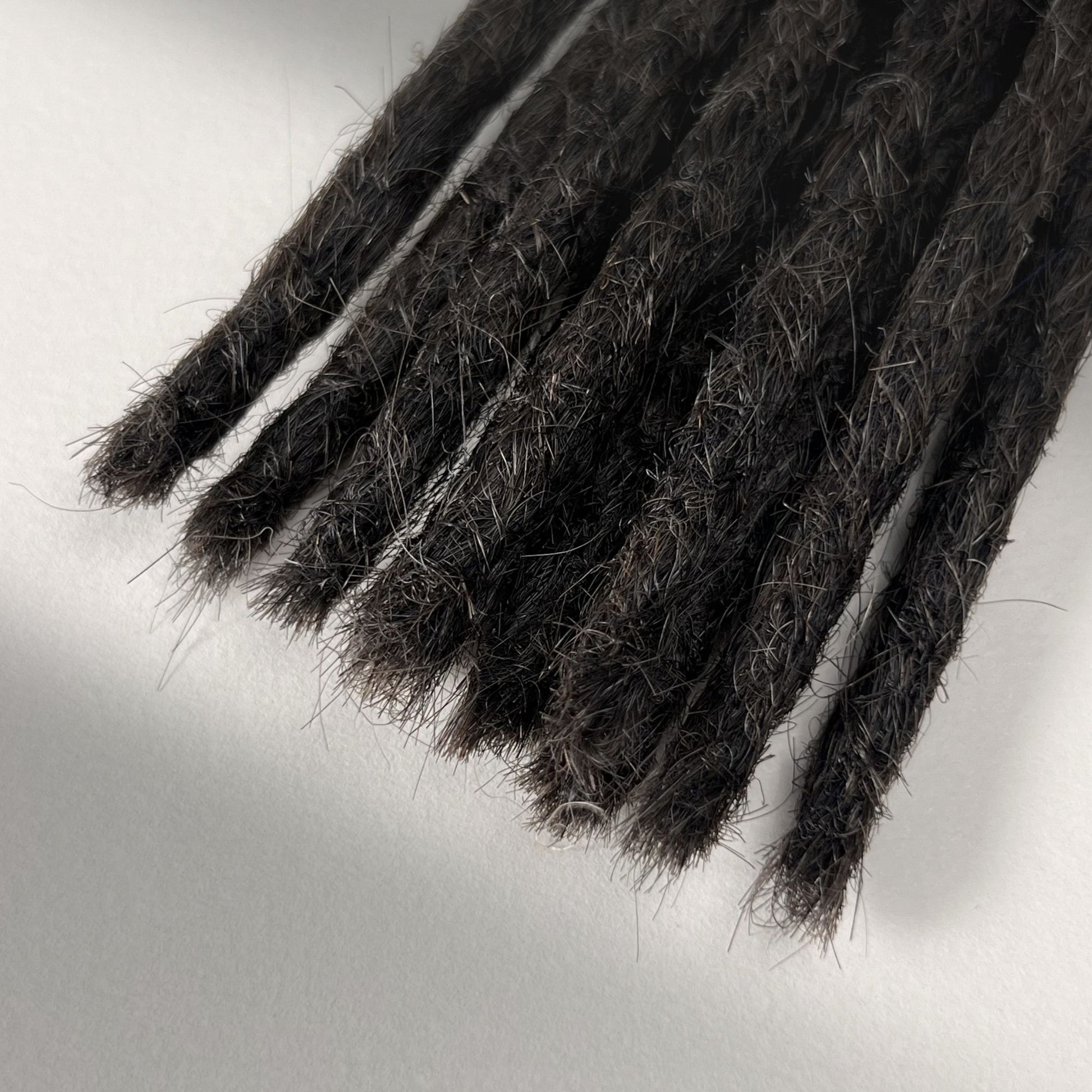 Tip detail of straight loc extensions with blunt ends in Warm Espresso Brown.