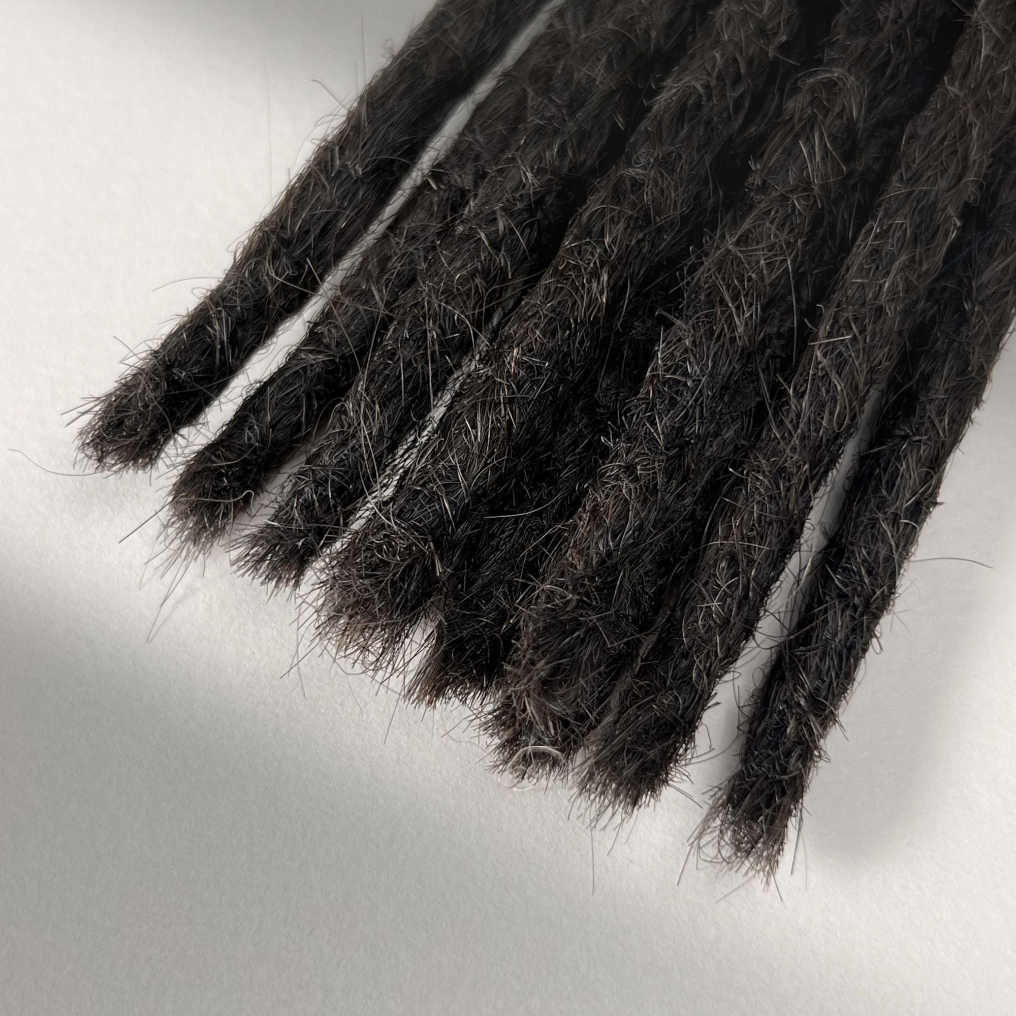 Tip detail of straight loc extensions with blunt ends in Warm Espresso Brown.