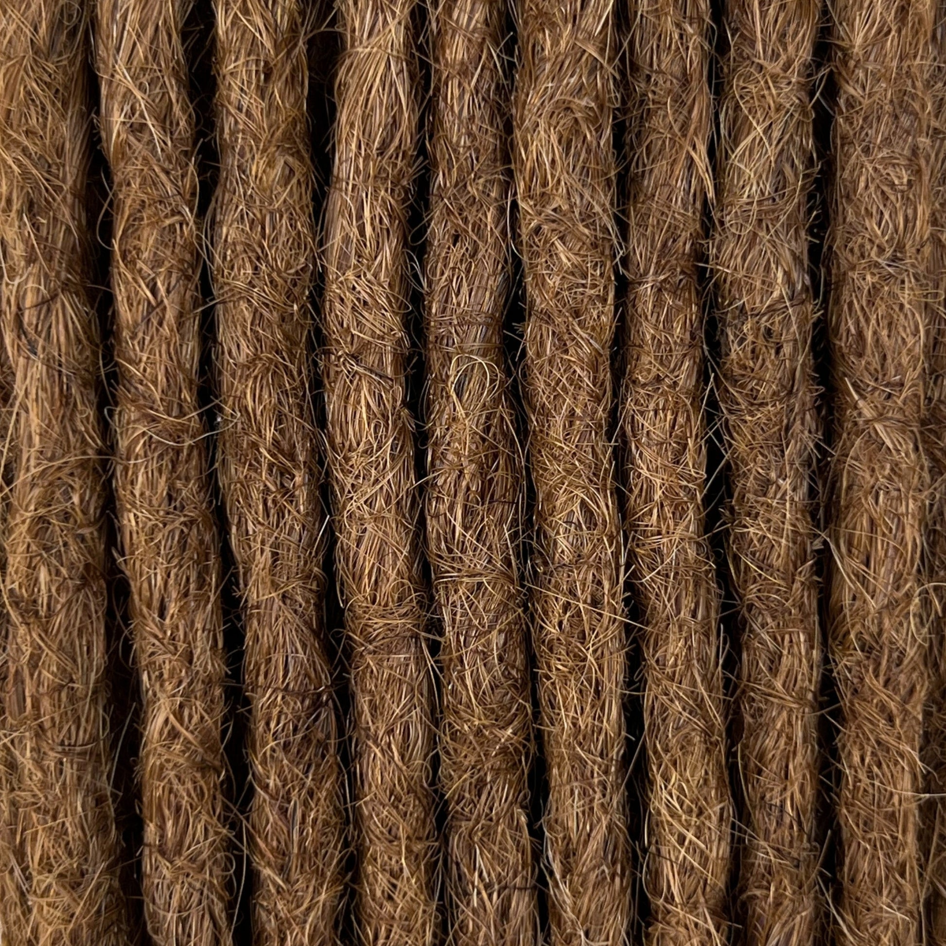 Close-up of straight loc extensions in Warm Golden Brown, showing the texture and color.