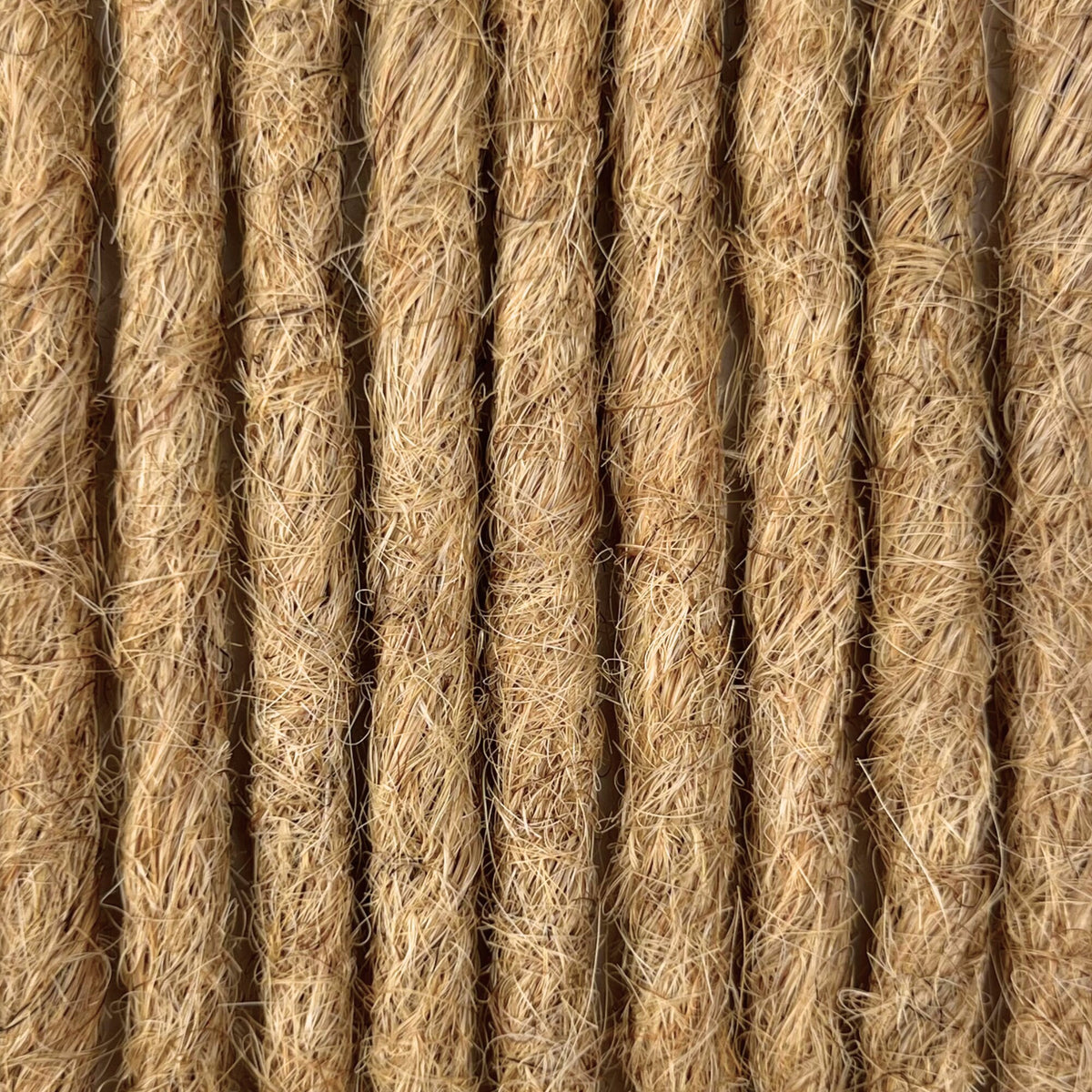 Close-up of straight loc extensions in Warm Beige Blonde, showing the texture and color.