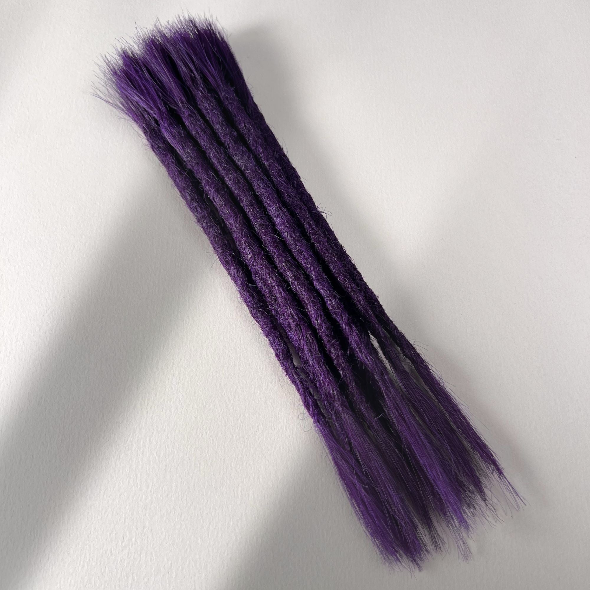 Full view of permanet straight loc extensions with open ends in Electric Violet.